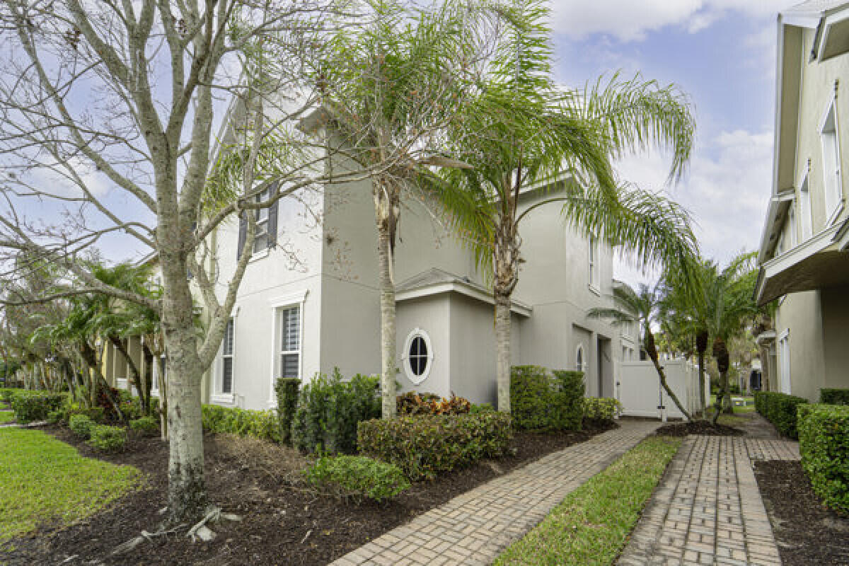 Your opportunity to own in the heart of Tradition in the desired subdivision of Bedford Park "A Porch Community" This beautiful updated corner unit of 3 BR / 2.5 BA with the master bedroom suite on the 1st floor. Walk and built-in closet with waterproof vinyl flooring. No carpets, Ceramic and Vinyl flooring throughout. Updated white kitchen 42" cabinets with quartz countertops and stone backsplash. The living room has 25' ceilings which brings in an abundance of light. The 2nd floor boasts a large loft area with 2 bedrooms and a full bathroom. Attached 2 car garage in the rear of the property. Metal roof which is covered by the HOA and hurricane resistant impact glass. Yard is completely fenced off with pavers and screened covered patio, great for entertainment, pets, children and more.  Easy walking distance to the club house, pool, shopping, restaurants and schools. No Tradition CDD! Call today for your VIP viewing! Gas Water Heater 2023 - Air Conditioner 2020