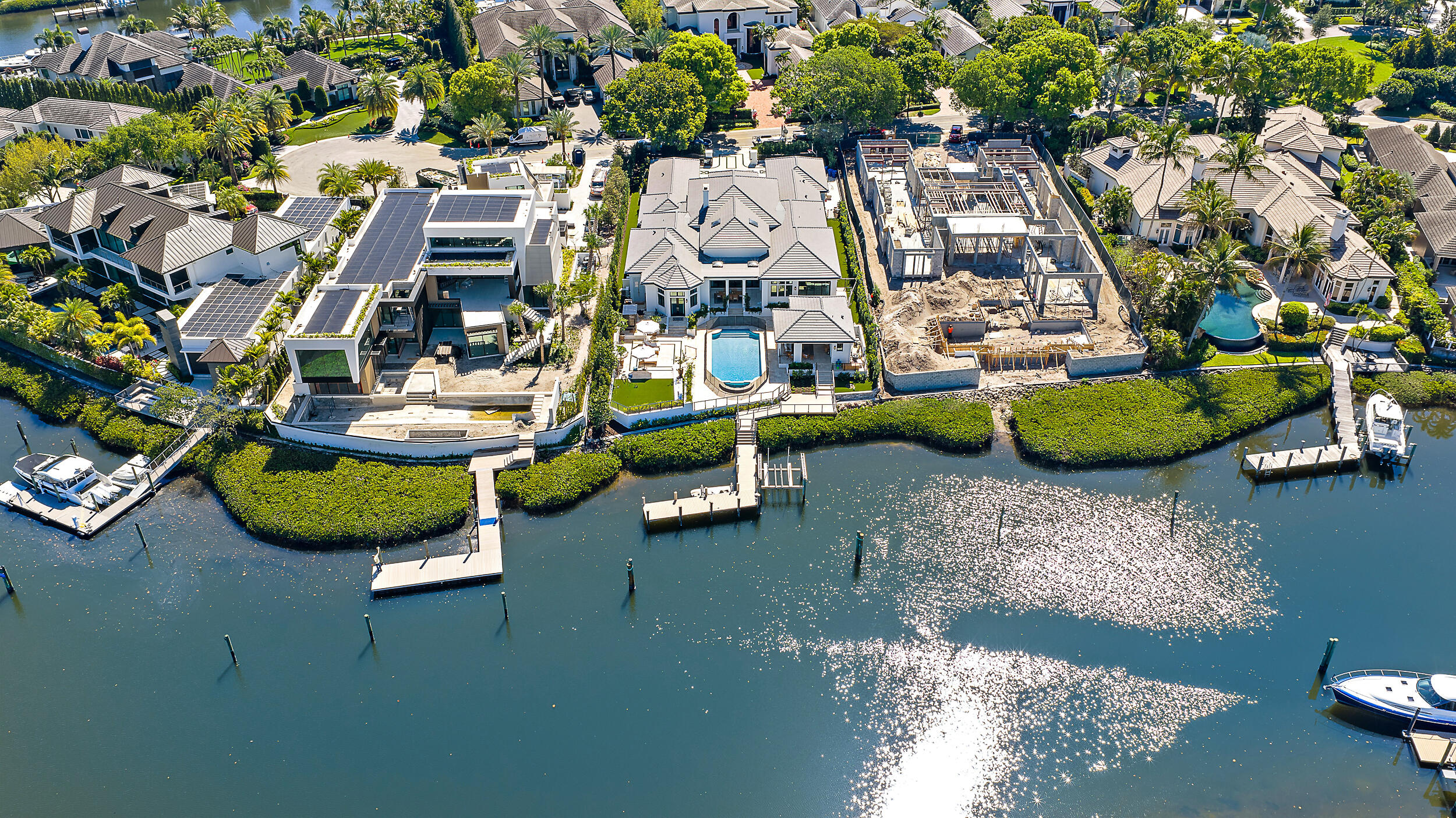 Located on a premier waterfront lot at the end of a cul-de-sac in Admirals Cove, 386 Eagle Drive sits on over half an acre—larger than most waterfront properties in the community—and has been extensively updated and thoughtfully redesigned with high-end finishes throughout. The home features a long canal view looking down the waterway, enhancing both the setting and privacy. The kitchen is designed for both everyday living and entertaining, featuring dual oversized islands with Cristallo countertops, a 60-inch Wolf range, Sub-Zero refrigeration, and custom Downsview cabinetry. The space opens to the main living areas and connects easily to the covered outdoor spaces, creating a functional indoor-outdoor flow. The primary suite offers a spacious retreat with a spa-inspired bathroom and custom-built closets. Marble flooring throughout the main living areas and wood flooring in the bedrooms complement the home's refined yet comfortable feel, along with updated lighting, millwork, and finishes throughout.  The property has undergone significant improvements including a new roof, impact windows and doors, updated electrical and plumbing, multiple HVAC systems, and whole-home Control4 automation.  The backyard is designed for entertaining, with multiple areas to gather, relax, and enjoy the waterfront setting. From the covered patio to the pool deck and green space, the layout offers flexibility for both intimate and larger gatherings. A private dock provides convenient water access.  Situated within Admirals Cove, residents enjoy a private club lifestyle with championship golf, marina, tennis and pickleball, fitness center, spa, and multiple dining venues.