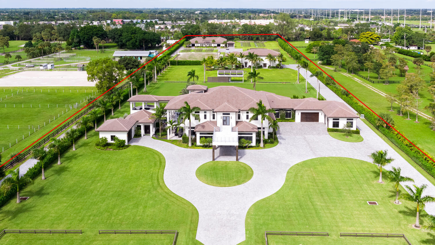 Look no further!  The ultimate trophy compound and private equestrian estate in one breath taking 8.7 acre property.  This is all new construction (never been occupied), originally built for the seller as a long term residence so no detail was overlooked, no corners were cut resulting in an unparalleled property that you have to see to believe.  This place is next level exceeding even the highest standards boasting top quality construction, lavish landscaping and over-the-top design and finishes. The stunning main residence has 6 bedrooms (w/ 2 masters) and an attached 2 bedroom guest house.  It's an entertainers dream with all of its outdoor spaces, theater, game room, gym, chef's kitchen, walk-in wine cellar, smart house system, endless balconies, 3 story observatory, huge grass sport/riding fields, outdoor kitchen, 2 putting green courses, pavilions, cabanas, massive auxiliary building set up to host parties/functions, indoor shooting range.  The equestrian features of this farm will also not disappoint as it is complete with a 40 stall barn, round pen, large all-weather arena and 3 additional grass riding fields, 3 bedroom groom's house. Space for covered arena!! The list goes on and on...


Main House Stats (Including attached guest house):

Main House Sq, Footage (8 Bedrooms, 8.5 Bathrooms) - 
1st Floor - 5,719 sq ft under AC
2nd Floor - 3,488 sq ft under AC
Total - 9,207 sq ft under AC
TOTAL sq ft with outdoor living spaces - 14,720
Guest House (2 bedrooms, 1 bathroom) - 
996 sq ft under AC
TOTAL sq ft with outdoor living spaces - 1,650

TOTAL AC (Main House + Attached Guest House) - 10,203 sq ft
TOTAL NON AC  - 6,348 sq ft
GRAND TOTAL Sq Ft:  16,551


Main House Amenities (Including attached guest house):

Large open stainless steel kitchen with large stainless farm sink, two Bosch refrigerators, microwave drawer, double oven with steam cooking, electric cooktop with downdraft, gas cooktop with separate draft, oversized large kitchen island with vegetable sink, kick toe lighting etc.
Exquisite bar with ice maker, sink, cabinets, plenty counter seating, counter space, pub tables, tv wired for area etc.
Large 4' x 8' Porcelain tile and 8" x 48" wood plank porcelain 
Large master suites downstairs
Full His and Her master suite upstairs
Downstairs master features 
two (his/her) large separate walk in closets with LED strip lighting 
Master bathroom features two soaker tubs
large dual entry shower with LED strip lighting
two separate toilet rooms
two separate vanities with LED mirrors
Upstairs master features
two separate large walk in closets with LED strip lighting,
features two separate bathrooms (His/Her) - each with LED strip lighting, Jacuzzi tub, large separate shower  enclosure, built in TV for the each tub, LED mirrors
Built-in closets that go all the way up to the top of the 12 ft ceiling with pull downs for easy access, extensive rotational shoe racks, and one closet features a hidden safety deposit box room
Morning kitchen equipped with separate private laundry, refrigerator, wine cooler, sinks, microwave etc
Large private balcony with built in gas line for Fire Pit; Balcony overlooks pool and backyard with a view of the property all the way to the back boundary 
Elevator for easy access to 2nd floor
State of Art Floating Horse-Shoe designed staircase
Oversized Family Room
Formal Living Room
Large Formal Dining
Den
Game Room
Theater Room
Gym
Office
Maid's Quarters (with exit door to outside pool area)
3 On-Suite Guest bedrooms upstairs with balcony access; walk in closets
Exquisite Modern window treatments throughout the house
Smart house lighting with pre-programmed scenes and access from smartphones and tablets
Large exquisite custom built 7' x 10' off centered pivoting front door 
LED strip lighting along several roof lines
Large front, side and back balconies
6 car garage (4 car at Main House, 2 car at guest house) fully AC'd and with Spray foam insulation for best insulation
Spray foam insulation throughout all the ceilings in the house plus added insulation coat in walls
Golf cart garage at the back of the garage
Covered carport behind the garage designed for a carwash
additional covered port adjacent to golf cart garage
3 Built in Fire pit gas lines - 1 upstairs by master and 2 down by pool deck
covered Cabana by pool deck with misting line around the perimeter
Built in outdoor kitchen 
All Covered Patios protected by hurricane screen and bug screen
Misting fans on all balconies to keep the temperature cool on any given day
Impact Heat annealed Windows throughout
Large Infinity pool with accompanying trough
Infinity spa with accompanying trough
Gas line at back of pool for added suspended fire feature
Both gas pool heater and electric pool heater for pool and spa
Automatic pool cover
Patio wired for outside TVs
5 hole Putting green (artificial turf) with lit holes
Reverse Osmosis system for entire house including pool and spa
2 - 1000 underground propane tanks 
Backup Generator
4 Tankless gas water heater  each Master Bath has a dedicated HWH


Barn and Equestrian Features:

40 stall CBS center aisle barn with 12 X 13 ft stalls, all rubber matted with individual fans and water to each stall with flyspray system throughout.  
8 wash stall, 2 AC tack rooms and 2 full bathrooms, 4 hay/feed rooms, 2 laundry rooms, T&G ceilings.
Complete privacy hedge, fully fenced and gated with separate driveway concealed barn driveway.
15 paddocks, 1 round pen, Fully irrigated All weather Arena with full drainage, 3 large grass riding arenas, Two viewing pavilions, excessive parking, large covered manure bin.  Space for a covered arena!!!


Auxiliary Building - Approx. 4000 under AC:

22 ft ceiling
All exterior walls are poured solid concrete
Spray foam insulation
40 ft long x 10ft wide X 15 ft high attached storage full concrete bunker 
Fully AC'd
2 overhead doors (14 ft)
Loft with 2 bedrooms, 1 bathroom with large shower enclosure
4 bathroom stalls and vanities with LED mirrors in total; split 2/2 on either side of the building to accommodate his/her situation
long run of stone counter top
Modern up/down lighting plus modern symmetric ceiling lighting
2 x 10ft sleek modern fans for improved air movement in addition to the AC in the building
Laundry (Front load washer and dryer)
Large balcony on back end overlooking artificial turf miniature golf course (7 holes)
interior kitchen
exterior kitchen area prepped with propane gas line
Hurricane screen to protect exterior kitchen
All impact windows
 

Groom's Cottage - 1,280 sq ft under AC   3 bedrooms, 2 bathrooms made with shipping containers:

Full Kitchen
Impact windows
Fully AC'd storage space (8ft x 40 ft) included in space with two double door access points for easy in and out. Storage space is foamed extensively for good insulation
washer/dryer
additional Spray foam insulation throughout.