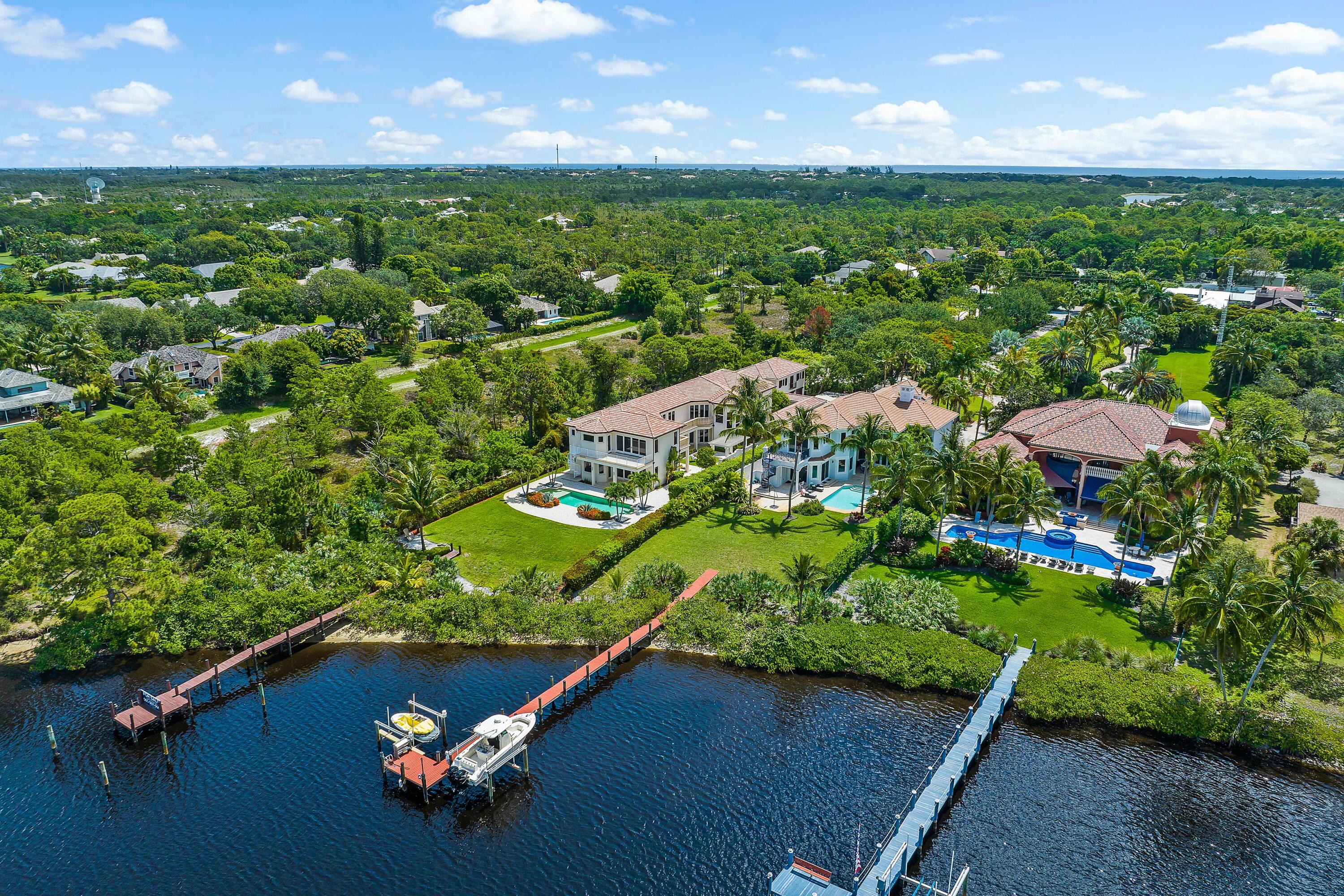 Treat yourself to the life of luxury and elegance you deserve with this spectacular riverfront custom estate built with the finest materials set on 1.1 acres of land. Anyone who appreciates flawless architectural design will fall head over heels for this remarkable residence. From the moment you arrive, the gated entry instantly sets the tone for this prestigious abode. At the same time, the long driveway builds anticipation as you admire the landscaping and approach the home. Here, a grand and stately entry invites you to step inside and explore the 5 bedroom 7.5 bath layout with a selection of sophisticated living spaces that can be adapted to your needs and lifestyle. The kitchen is complete with stone countertops and Downsview wood cabinetry. There are two islands and a raised breakfast bar with quality fixtures and premium stainless steel appliances, including a Galgano steam oven, Adventium oven, and a dual fuel gas stove. The eager cook can overlook the river from the family room and breakfast nook, plus there's also a well-appointed wet bar where you can whip up delicious drinks before stepping outside to admire the sparkling river views. A formal dining room with a wood-coffered ceiling is ready for more intimate affairs, and there's a living room with a double-height ceiling and a fireplace. Extended the floor plan further are the game room, fitness room, and spacious office, while a wine room is ready to store your collection. And the large owner suite has a Morning bar door, custom cherry closets, and an oversize shower with acid-etched Botticino floors. There's even a large private balcony off the primary bedroom with awe inspiring river views. Included in the selection of bedrooms is a 667 ft.² guest house with a full kitchen, a separate entrance, and a washer and dryer for visitors. The captivating list of extra features includes impact glass throughout an elevator to laundry rooms, a three-car garage, and Martin County taxes. Outside, a sparkling heated saltwater pool, multiple courtyards, and a covered patio press any avid entertainer, and there's a private boat dock that can accommodate up to a 40-foot boat.