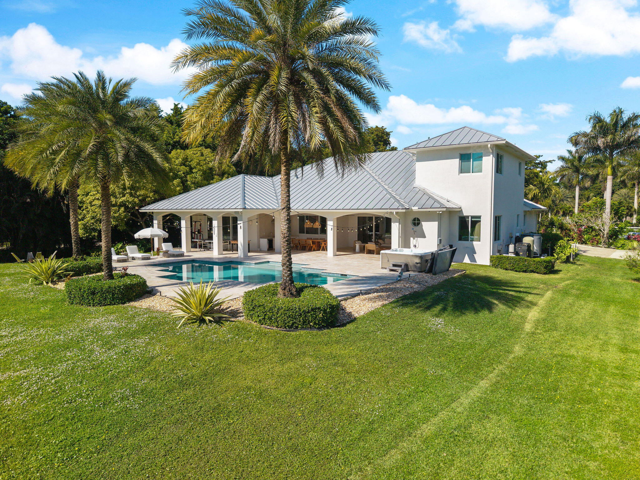 Nestled in the beautiful landscape of Southwest Ranches this exceptional estate offers casual luxury on over 2 acres of lush tropical grounds. Built in 2016 and fully renovated with the guidance of a professional interior designer the home features custom finishes high end materials and detailed craftsmanship throughout. The chefs kitchen includes premium Thermador appliances gas range and a large center island perfect for entertaining. Open living spaces high ceilings and expansive impact windows fill the home with natural light and connect seamlessly to the outdoor retreat. Enjoy a resort style pool summer kitchen and covered patio ideal for relaxing and outdoor dining. A rare opportunity to enjoy privacy space and luxury while remaining close to major conveniences.