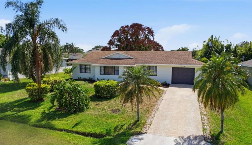 Fully renovated with NEW kitchen, 2 Bonus Rooms, and over 10,000 square feet of outdoor space with a new wooden fence being installed, this move-in ready Port St. Lucie home offers far more living flexibility than a typical 3-bedroom home with no HOA.  Freshly painted inside and out in alabaster white with luxurious black accents, the home features new honey wood-look luxury vinyl plank flooring throughout, sleek recessed lighting, updated ceiling fans, designer fixtures, a NEW AC, NEW water heater, and a roof that is only 9 years old.  The stunning new kitchen has been completely redesigned with white shaker cabinetry, brushed gold hardware, quartz countertops, stainless steel appliances, subway tile backsplash, and exceptional cabinet and countertop space.  The kitchen flows seamlessly into the spacious living and dining areas, highlighted by a modern chandelier and abundant natural light.  The primary suite features a beautifully updated ensuite bath with a new vanity, mirror, lighting, and tile finishes.   The guest bathroom has also been renovated with a new vanity, updated lighting, and a tub/shower combination. All bedrooms are generously sized and feature the same luxury vinyl flooring that runs throughout the home.  One bonus room is located directly off the kitchen and includes a pass-through window and direct backyard access.   The second bonus room is privately positioned beyond the guest bedroom. Both bonus rooms extend across the rear of the home and feature surrounding windows that fill the space with natural light.   Whether used as an extra bedroom, office, a playroom, fitness space, media room, guest retreat, or sunroom, these spaces provide flexibility rarely found in this price range and create additional space for relaxing, entertaining, and enjoying Florida living.  The laundry room features checkerboard tile flooring, washer and dryer, and space for a utility sink. The one-car garage has been freshly painted, and the oversized 10,000+ square foot lot will include a new fence for the new owner.  With major system updates already completed, modern finishes throughout, and multiple flexible living spaces, this home is ready for its next owner to move right in and enjoy.   Centrally located near both the Florida Turnpike and I-95, this home provides effortless access throughout the Treasure Coast. Enjoy proximity to Crosstown Parkway, Lyngate Park, the Port St. Lucie Civic Center, and a short drive to the beaches of Jensen Beach and Hutchinson Island.   Shopping, dining, and entertainment are close by at Town Center at St. Lucie West and along SE Port St. Lucie Boulevard's growing corridor.   Golfers and outdoor enthusiasts will appreciate nearby PGA Village, The Saints Golf Course, Clover Park (home of the New York Mets' Spring Training) and easy access to nature preserves, kayak launches, and world-class fishing.   This property is a rare opportunity - modern, move-in ready, and perfectly positioned to enjoy the best of Port St. Lucie's fast-growing community and coastal lifestyle.  Explore more property information via the Virtual Tour link.