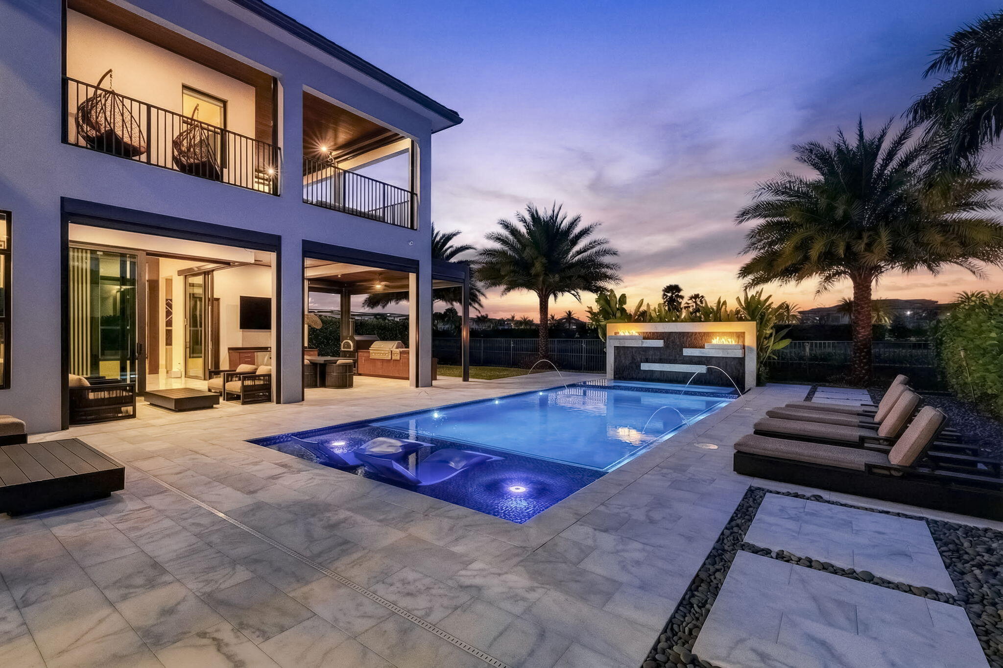 Located in Boca Bridges, one of the newest luxury communities, built in 2022, this exceptional estate blends modern elegance with resort-style living. Boca Bridges is a gated community offering a grand clubhouse, tennis and pickleball courts, basketball, fitness center, playground, and resort pool. The home features four upgraded garages with epoxy floors and custom storage, a modern elevator, circular driveway, and a fully integrated smart-home system. The primary suite offers his-and-hers custom closets and spa-style baths with multi-jet showers and soaking tub. Outdoor living shines with a custom Van Kirk pool, spa, fire features, and waterfalls, plus a private custom movie theater for ultimate entertaining. Not builder grade, lots of upgrades. Must see.