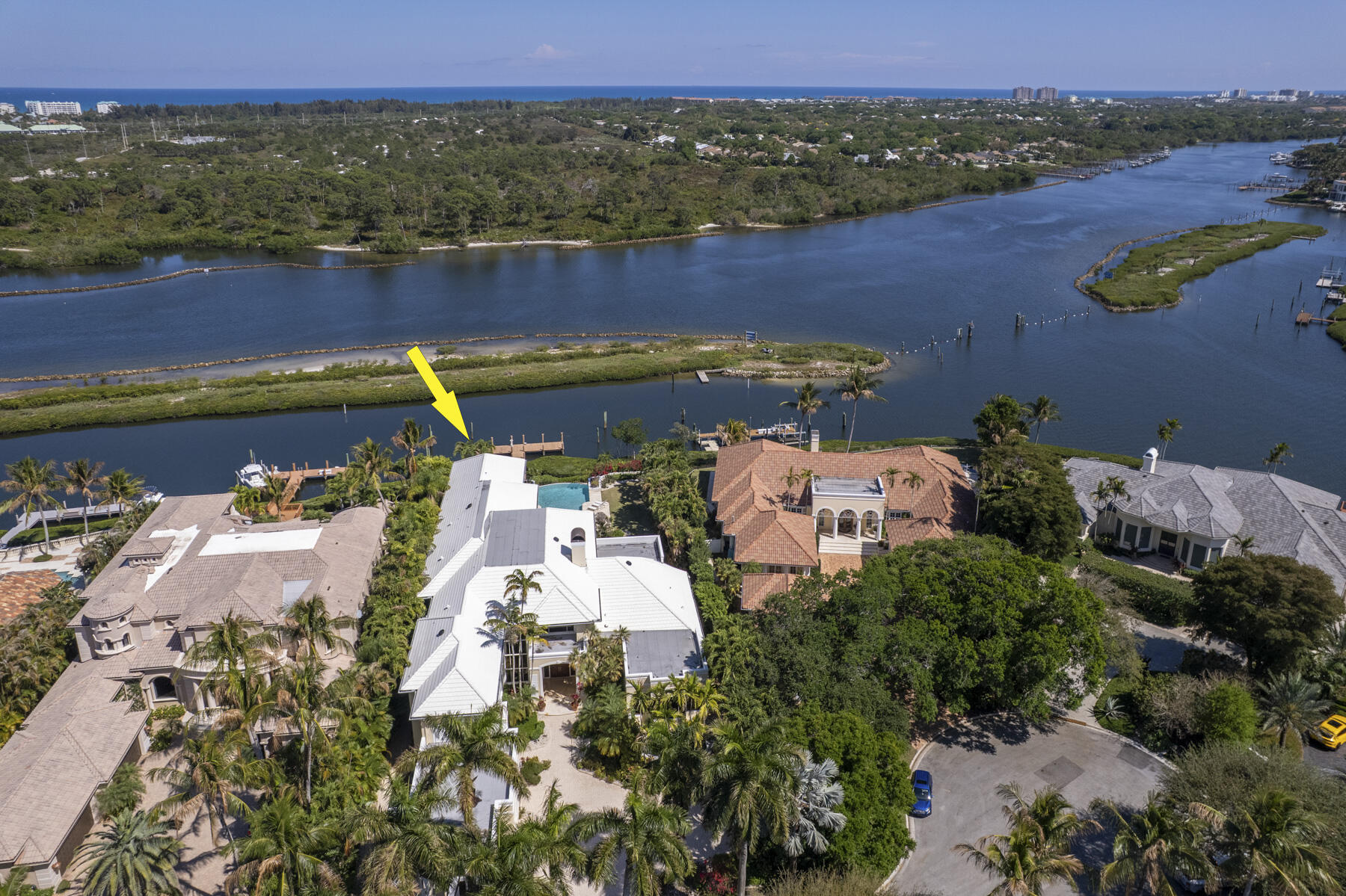 Rare opportunity to own on one of Admirals Cove's most coveted streets, Spyglass Court. Enjoy breathtaking views across a protected barrier island with no homes across the water, offering exceptional privacy and sweeping water views. Situated on an expansive 28,749± sq. ft. lot with 102' of waterfrontage, 9,290 sq. ft. U/A.  This residence features soaring ceilings, and water views from nearly every room. The primary suite boasts a newly renovated bath, with upstairs private guest suite with kitchenette for visitors. Designed for seamless indoor-outdoor living, the expansive loggia and summer kitchen create the perfect setting for entertaining. This home is a boater's dream with a private dock, no fixed bridges, and quick ocean access! Come Experience the ultimate Admirals Cove lifestyle.  GOLF MEMBERSHIP available for purchase, coveys all the first class   amenities of Admirals Cove including two spectacular clubhouses, 45 holes of golf, 5 restaurants, 58 slip marina with floating docks, Yacht Club, 9 har tru tennis courts, 12 pickleball courts, state of the art fitness and wellness center with Technogym machines, 21,000 sq ft spa & salon, 30 room Waterside Private Boutique Hotel for members and their guests, brand new Golf Learning Center, Covesters kids club, dog park and Platinum service. Close to Palm Beach international airport .