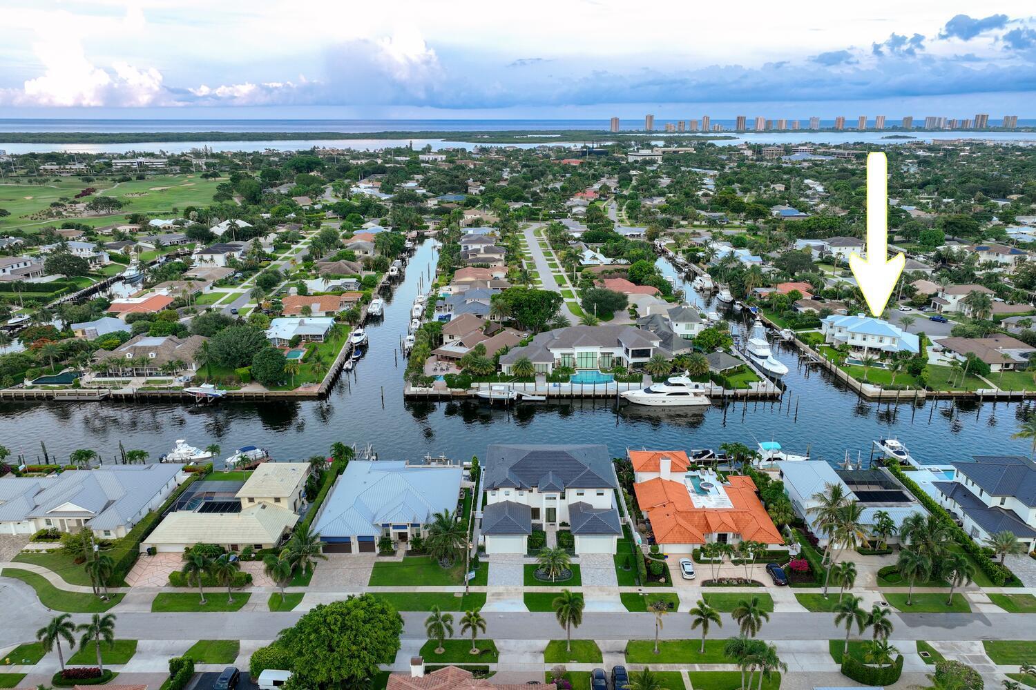 Welcome to 643 Pilot Road, an extraordinary custom-built estate by RJS Builder Inc., where craftsmanship, innovation, and coastal elegance come to life. This one-of-a-kind home offers 5,332 square feet of luxurious living space (7,651 total) with breathtaking water views from every room—designed to impress and built to endure. Set on a .43-acre lot with 240 feet of water frontage, the property features new seawall and caps, and a unique lot configuration measuring 52 x 173 x 49 x 190 x 110.From the moment you step inside, the architectural detail is unmistakable. Tongue and groove ceilings with exposed beams span the foyer, living room, kitchen, primary bathroom, and loft, while the office showcases a stunning pecky cypress inverted hip ceiling. The foyer wows with intricate wall trim and patterned flooring, setting the tone for the level of craftsmanship found throughout the home.  The chef's kitchen is as functional as it is beautiful, featuring Thermador appliances, Calacata Silver Quartz countertops, custom cabinetry, and a full-height backsplash with a tile inlay behind the range. The built-in AV hub tucked under the stairs offers Cat6 drops at every TV location, signal jumpers for whole-home coverage, and prep for soffit cameras and a smart doorbell. Every element is thoughtfully designed from the 46" Isokern ventless fireplace with herringbone firebrick to the custom cast stone surround that serves as a bold focal point in the living room.  This residence boasts 5 spacious bedroom suites, 6 full bathrooms, and 1 powder room each space crafted with refined materials and finishes. Upstairs, the loft features a built-in double desk, while the downstairs office offers both built-in storage and a custom desk setup. The bathrooms are finished with a curated selection of materials, including Cristallato Marble and Borghini Modena Quartz, with shiplap and a board-and-batten millwork feature wall behind the freestanding tub in the primary suite.  Designed for both elegance and utility, the home is built on structural helical piles for maximum stability and includes a 48kW whole-house generator with automatic transfer switch. Outdoors, enjoy the best of waterfront living with a 40,000 lb Golden boat lift, an additional 15k lb lift, and a dedicated boat storage garage. The pool and spa feature both gas and electric heating, while the outdoor living area includes a summer kitchen, comes equipped with motorized screens, and is prepped for a sauna, cold plunge, and fire pit.  Additional highlights include all Marvin windows and doors (including a woodgrain aluminum front door), white oak flooring upstairs, dual laundry rooms, and a third rear-facing utility garage. With underground drainage, natural gas service, and an unbeatable location, 643 Pilot Road is the definition of Florida luxury living. This home is more than just a residence it's a statement. A rare opportunity to own a true waterfront masterpiece in the heart of North Palm Beach.