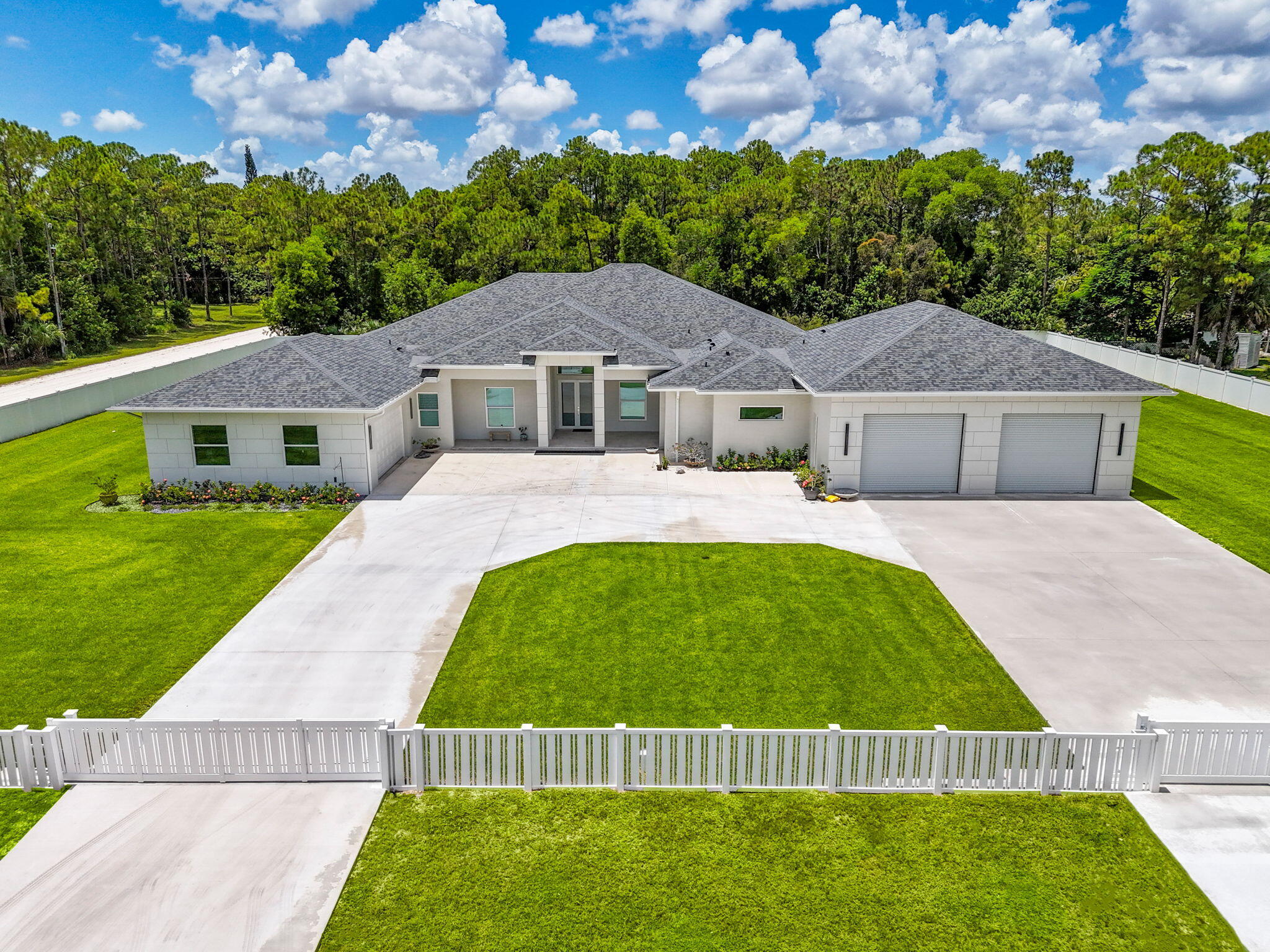 Experience unparalleled luxury and craftsmanship in this meticulously designed custom home, showcasing unique upgrades and premium finishes throughout. Nestled on a beautifully landscaped lot with a 4' privacy fence, the property is enhanced by a lush St. Augustine lawn maintained by a sprinkler system. The owners have invested well over $60,000 to properly fill and elevate the lot, ensuring superior drainage and eliminating any potential water-related concerns for years to come. A whole-house reverse osmosis system and a 4'' deep well with pump ensure exceptional water quality and efficiency. The exterior boasts energy-efficient double impact argon-filled windows and 8' doors with custom handles, while the interior features expansive 16' sliding glass doors that lead to a (continued) stunning porch with a custom-built wood-burning fireplace.

Step inside to discover luxury laminate flooring and soaring 12' and 13' ceilings that create a spacious and elegant ambiance. The chef's kitchen is a masterpiece, featuring Quartzite countertops with a full backsplash, an oversized kitchen sink, and a custom cooktop backsplash by Haven Metals. A massive 6' x 12'6" island with a waterfall edge complements the suite of KitchenAid appliances, including a wine fridge. All-wood cabinetry with custom hardware and glass display tops adds a refined touch, while the fully equipped butler's pantry offers additional storage, Quartzite countertops, a built-in fridge, microwave, and floating shelves.



The master suite is a sanctuary of luxury, with custom wood vanities featuring pullouts, polished nickel hardware, and a Quartz countertop that cascades into the walk-in shower. The master bathroom also includes a freestanding soaker tub with a polished nickel floor filler, a frameless glass shower with large-format tiles and recessed shelves, and polished nickel Kohler fixtures. Each ensuite bathroom throughout the home mirrors this level of elegance, with solid wood vanities, Quartz countertops, frameless glass showers, and large-format tiles, while the powder room stands out with a Quartzite countertop, custom sink, and faucet.



The home's functionality matches its beauty, with a laundry room featuring all-wood cabinets, Quartz countertops with a waterfall edge, and an undermount sink. Energy efficiency is ensured with full spray foam insulation, two tankless water heaters, two A/C systems, and soundproofed interior walls. Ceiling fans are installed throughout the home, while full-skirted Kohler toilets add a final touch of refinement. The warehouse is equally impressive, featuring spray foam insulation, sheetrocked ceilings, and a bathroom with Quartz countertops, an undermount sink, and Kohler fixtures.  The outdoor patio is ultimate backyard retreat fully screened with picture frame style screens to not obstruct your amazing views into the backyard.  Outdoor patio is fully tiled with rectified porcelain making it a breeze to maintain.  There is not anything not thought of with this home.

This home exemplifies the perfect blend of luxury, design, and practicality, offering an unmatched living experience for the discerning buyer. Don't miss your opportunity to call this exceptional property your own.
