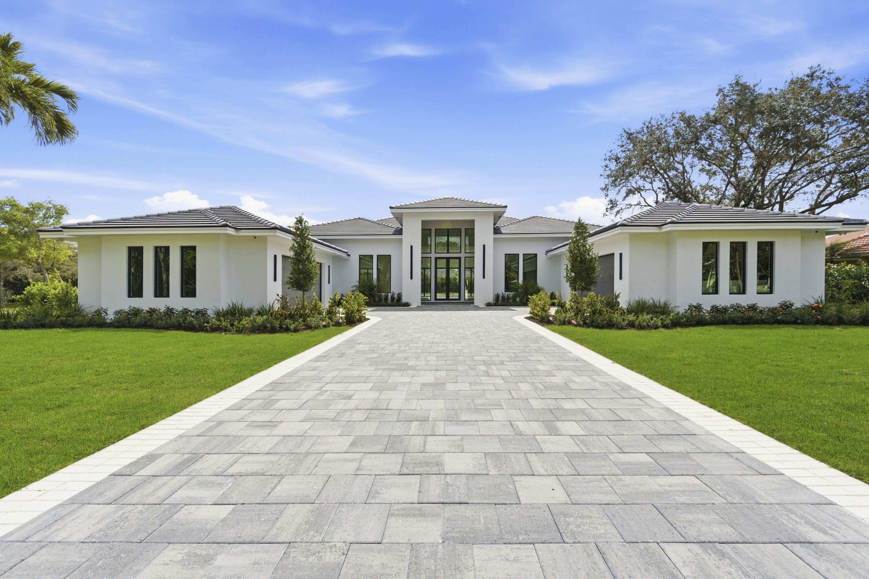 An exceptional new construction estate set on a prime lot within the prestigious, gated community of Steeplechase. This single-story residence offers 5 bedrooms, 5 full baths, two half baths. 4,993 sq ft of refined living space (6,930 total). A grand 17-foot foyer opens to a stunning great room with soaring 14-foot ceilings and walls of glass that seamlessly connect to a private courtyard oasis. Outdoor living is elevated with oversized porcelain pavers, artificial turf, and a 16 x 50 saltwater pool featuring sun shelves, deck jets, bubblers, spa, and an expansive covered patio with a 20-foot summer kitchen. The chef's kitchen showcases a 15-foot mitered quartz island, custom cabinetry, full backsplash, pantry, and a complete Sub-Zero/Wolf/Cove appliance suite. The primary retreat offers pool views, dual walk-in closets, and a spa-inspired bath. Additional ensuite bedrooms, 4-car garage with EV charger, impact glass, smart wiring, and lush landscaping complete this refined offering, minutes to golf, dining, PBI, and Palm Beach beaches.