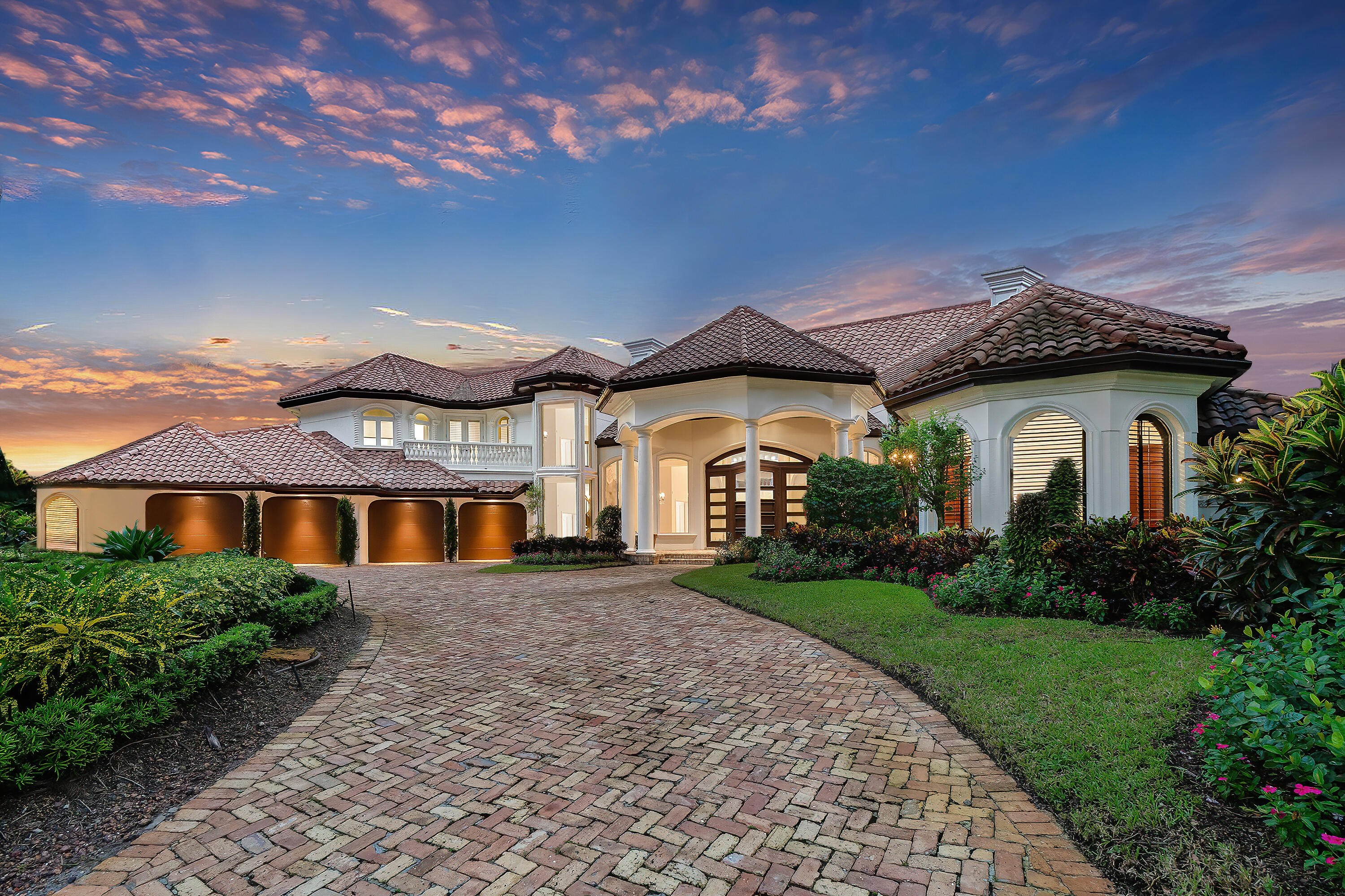 This refined Palm Beach-inspired masterpiece is situated on .62 acres with spectacular panoramic lakefront and golf course views. A graceful arched entry sets the timeless tone of this 5 bedroom, 6.2 bath residence with 9,211 square feet under air. The classic look is fashioned with custom architectural elements, exquisite designer finishes, marble and wood floors and stunning ceiling treatments throughout. The flow functions beautifully for entertaining with French doors to the outdoor living room, summer kitchen and luminous pool with spa and fountain in a relaxing resort-like oasis. Notable features of the home include the authentically designed theater, large family room, and primary grand suite with a luxurious bath and generous closet space. Additionally, a chef's kitchen features top of the line appliances, center island and breakfast area with large wine room. Other amenities include 4 bays plus golf cart garage, impact windows and doors and full house generator. The information herein is deemed reliable and subject to changes, omissions and errors without notice. All measurements are approximate.
