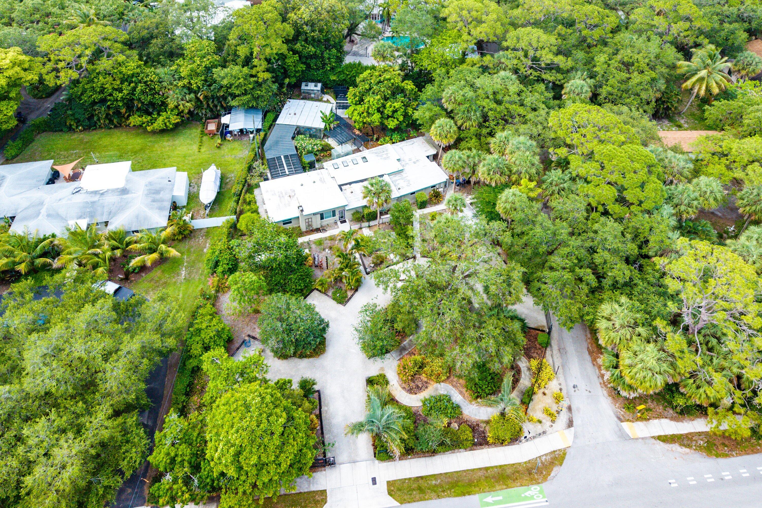 Situated on an exceptional & rare oversized lot (3/4+ acre) of paradise-like landscape & within a community of multi-million-dollar estates.  The residence features all impact windows/doors, along with a private in-law suite complete with a kitchen & separate entrance.  Inside, you'll find an open floor plan & a very large main kitchen. Enjoy an expansive covered porch & additional outdoor living spaces. Mature trees, a wide variety of fruit trees, vegetable plants, greenhouses create a truly private residence.  This is a rare opportunity in one of Fort Lauderdale's rapidly transforming luxury corridors for those seeking space, privacy and vision within a metropolitan area. The lot is zoned RS-3.52