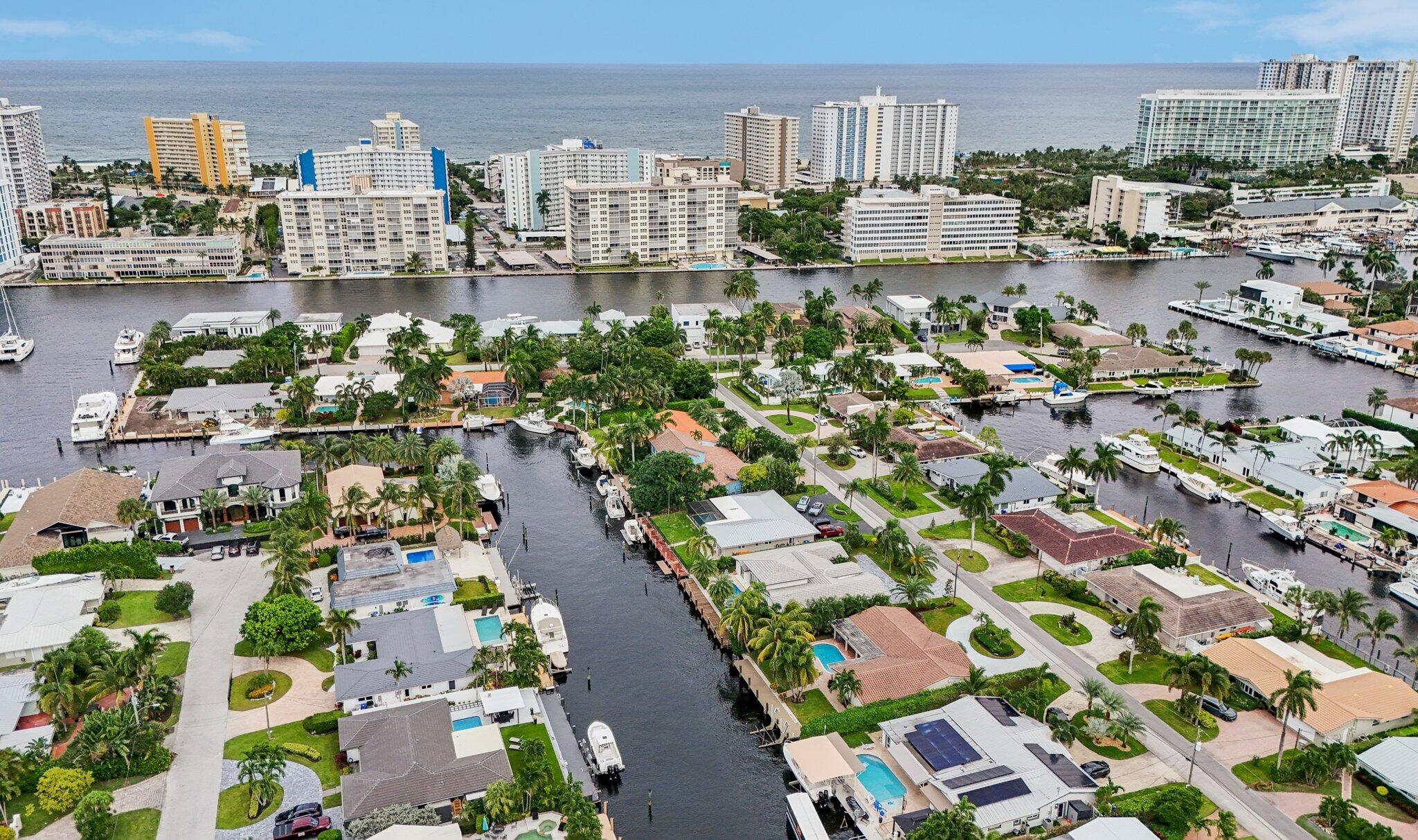 100FT-wide protected T-shaped canal—located on 80FT no fixed bridge deepwater frontage. An elite yachtsman's and fisherman's canvas to tailor for up to a 70FT vessel. Direct ocean access with just a 10-15 minute run to The Hillsboro Inlet. This refined coastal-modern residence features an open split floor plan featuring three suites with cabana bath, New PVC plumbing, travertine floors, and full impact glass windows and doors. Designer chef's kitchen with custom cabinetry, gas cooktop, premium appliances, and wine chiller. Interior laundry with natural gas, & separate washer/dryer room. Updated Resort-style heated pool and lush greenery. Spacious primary suite with custom closet overlooks the waterway/pool from 2 sets of glass doors Only 5 blocks to the beach, dining, and entertainment!