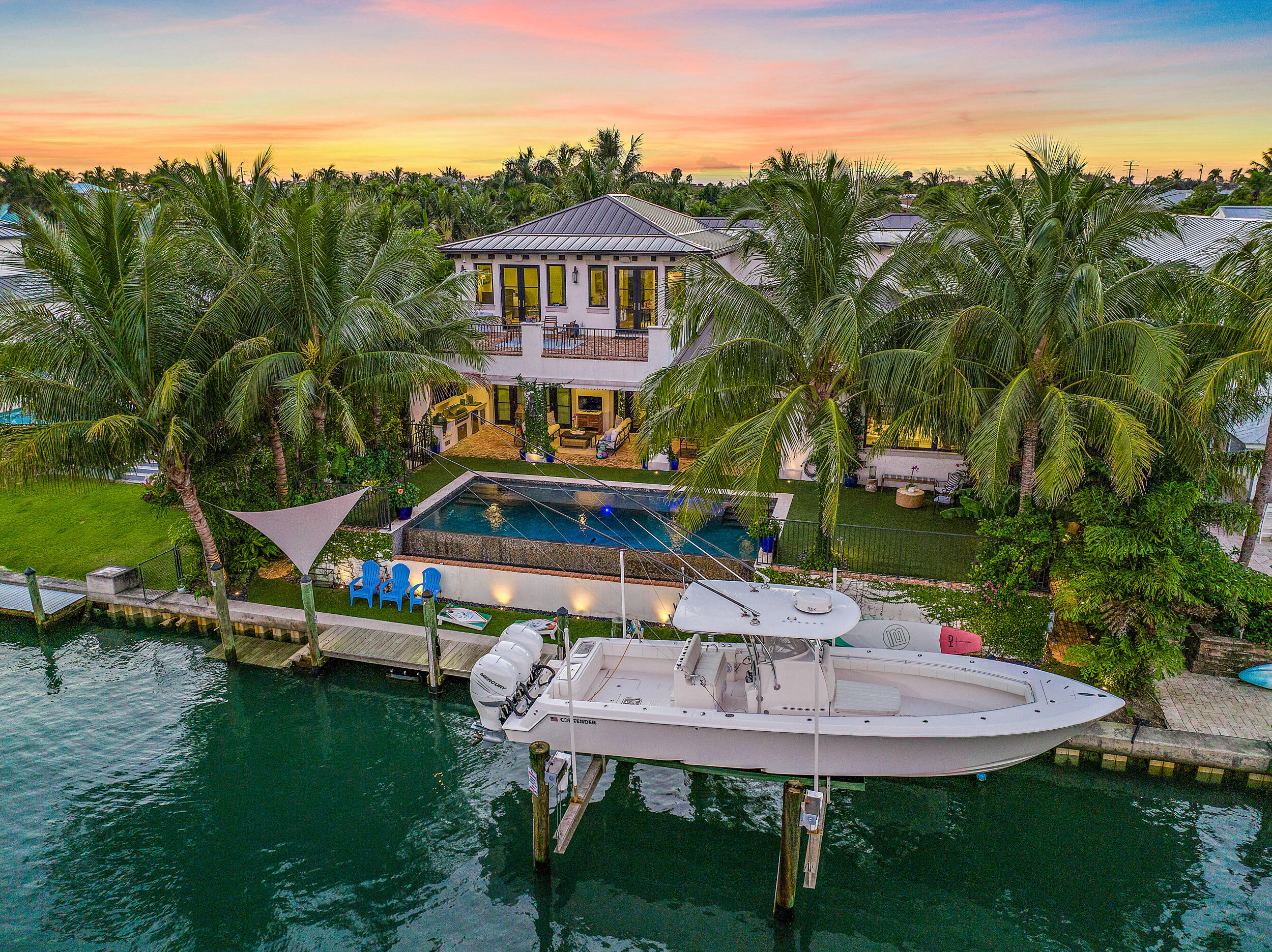 This custom built waterfront home (2017) is nestled in Waterway Village, one of Jupiter's most sought after Bluewater communities. A rare find just less than 1 mile from the Jupiter inlet with no fixed bridges and turquoise blue water at all tide levels.  In the backyard you'll enjoy a true Florida life style as the lot has 90 ft of water-frontage and a dock with a 20k lb boat lift. A large covered deck with outdoor kitchen is perfect for entertaining and looks out on the custom built heated salt water pool. Inside the home you'll find hardwood floors throughout, a beautiful custom kitchen with large island, Thermador gas range, and views of the water. A ''hidden'' den is tucked behind a painting just off of the living room. Waterway Village has a low HOA with little restrictions and a private waterfront park with day dock accessible with a key fob. Conveniently located by local boutiques and popular restaurants.