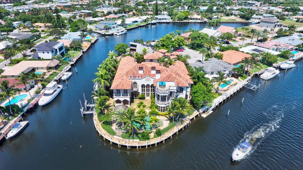 A Majestic Trophy Estate, Chance of a Lifetime to own this private gated and walled Euro/Mediterranean styled waterfront point lot. After entering the gates into the courtyard you have complete privacy with 285 feet of water and docks surrounding the property and a nature preserve (Capone's Island) behind this magnificent compound. Come into the main home and be wowed by the volume and quality of the wood work and design with fireplace built in aquarium wine room-- and a half-court basketball court and gym. The Elevator takes you to the multi room master suite on the 2nd floor with its long range water views that cant be duplicated at this price. There is security throughout with a ''Safe Room'' The separate guest house has a garage, 2 beds, 1.5 baths. The resort pool area which will rival many fine resorts is palm lined with an island waterfall, a swim up bar, summer kitchen, entertainment loggia. Boaters use the lifts or dock your mega yacht right out back. Royal Palm yacht club just seconds away from your docks and just minutes to the Boca Inlet and Atlantic Ocean.  Dont miss this opportunity.