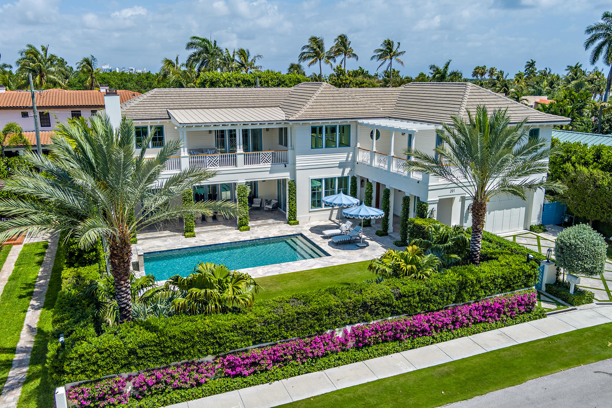 Located at the end of a quiet cul-de-sac in the coveted SoSo neighborhood, this 2023 built residence offers 5 bedrooms, 6 full baths, and 2 half baths across 7,764 total sqft. Hardwood floors run throughout, enhancing a bright, airy interior defined by clean lines. The chef's kitchen is beautifully appointed with a 6-burner Wolf gas range, dual Miele dishwashers, a large pantry, and a custom wet bar complete with a beverage cooler, freezer, and wine cooler. The kitchen flows into a well appointed dining room and spacious living room overlooking lush, manicured gardens. The thoughtfully designed layout includes a main-level bedroom, a private office, and den offering flexibility for guests or work-from-home living. Upstairs, the primary suite features dual bathrooms each with custom closets, including one with a Roman tub and a second with a steam shower and coffee bar. Off the master, a private terrace with an outdoor fireplace offers serene views of mature banyan trees. The level is completed by three additional spacious bedrooms, each with en-suite baths, along with a dedicated second laundry room.  Designed for seamless indoor-outdoor living, the home features a covered loggia with automatic retractable screens, pool, spacious yard, and a fully equipped summer kitchen with a Hestan grill, Gozney pizza oven, sink, beverage fridge, and ice maker. Additional highlights include dual laundry rooms and a two-car garage. Ideally located just minutes from downtown West Palm Beach, Palm Beach Island, pristine beaches, and PBI Airport, this home offers convenient access to premier dining, shopping, and entertainment.