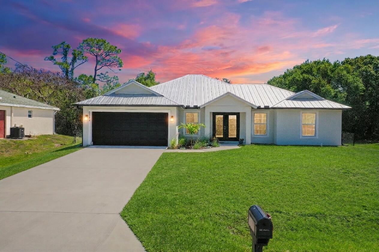 Experience modern luxury in this stunning 2023 built home! This 4-bedroom, 2.5-bath 2 car garage gem is truly better than new! This home outperforms new construction by offering high-end upgrades you won't find in a base model, including designer fans, modern lighting, rain gutter and a complete washer and dryer set. The open-concept interior features tile flooring, granite countertops, and stainless steel Smart appliances arranged in a desirable split-bedroom configuration. Built for peace of mind, the property boasts a durable metal roof and full impact-rated windows and doors. If your plans include entertaining, the expansive paver patio, private backyard tiki bar and fenced in yard highlighted by professionally upgraded landscaping is the perfect spot! Schedule a private showing today!