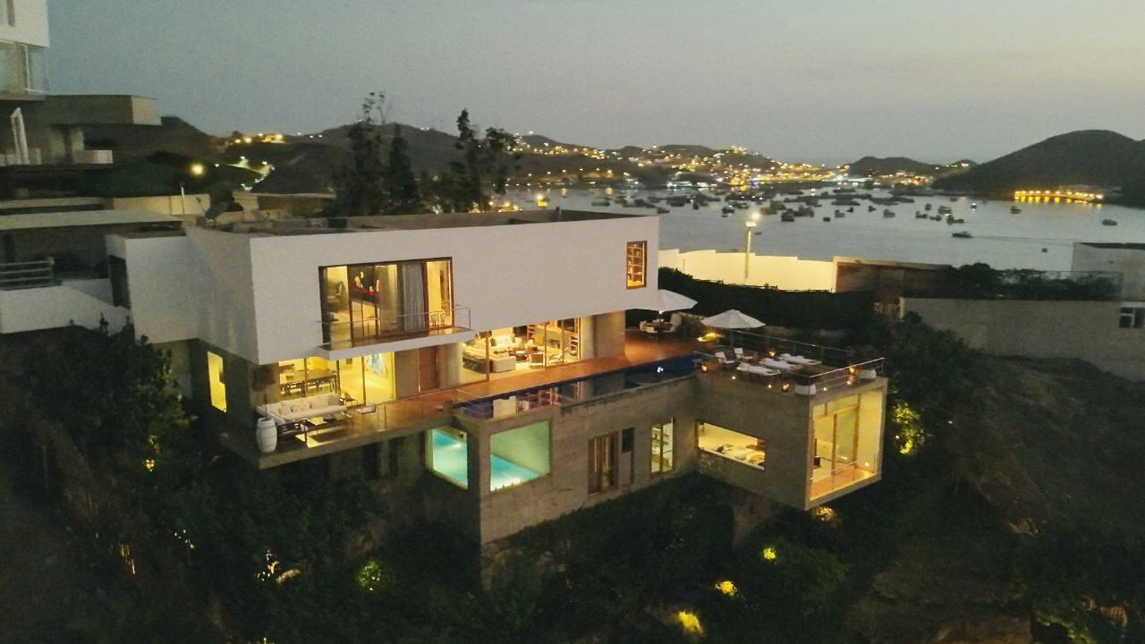 Behold the breathtaking beauty of this magnificent 4-level Luxury Ocean Front Home, nestled along the Pacific Ocean coast amidst lush green trees, gardens, and a serene pergola perfect for meditation. With two entrances through the yacht club streets, this one-of-a-kind property is a true masterpiece. Designed by the prestigious builder and architect David Mutal, this home is a piece of art. The property boasts 3 living rooms, a cozy fireplace, 2 dining rooms, 2 kitchens, 3 master bedrooms (suites), 2 guest bedrooms, walk-in closets, 8 bathrooms, 2 balcony terraces, an outdoor pool, a gym and spa with an heated indoor pool, steam & dry saunas, and a massage room. A loft office/studio, two maids quarters with a bathroom, 5-car garages and laundry room. Also includes a Guest/Guardians house, 2 storage rooms and a machinery room. These components can cater to all your daily needs.

Step inside and be awestruck by every thoughtful detail within the design of the house. The radiant floor adds a touch of warmth to the contemporary high-ceiling design. The sound system, integrated throughout the common areas, is sure to take your experience to the next level. The automatic irrigation system & lights in the beautiful gardens are a testament to the intentionality that has gone into making this property a beautiful showpiece.

Owning this home includes access to the exclusive Nautical Club Poseidon, a gated yachting community with a select number of multi-million dollar homes. The club offers water-sports & social events all year round, adult & children's pools, tennis courts, basketball courts, turf soccer fields, fronton, medical post, club house, restaurants, chapel, area for people with hand football tables & private roundabout, and a mini-market sponsored by "La Canasteria". The docking space for boats, yachts, catamarans, and jet-skis make it a perfect place to indulge in your love for the sea.

Golf carts for transportation around the club, or from your house to the beach and/or dock, this service is included in the maintenance fee, ensuring that every need is fulfilled.

Escape from the chaos of the city and enjoy magical moments with unbeatable views in complete safety and security. Poseidon is located just 45 minutes away from Lima (kilometer 57 of the Panamericana Sur). This unique and excellent project was developed by Grana & Montero, Rodrigo & Asociados, and Poseidon Investments.

This Dream Ocean Front Mansion is not just a seasonal home, it's a gem meticulously created & designed to be a shelter to enjoy any time of the year.  The design takes into account the evolution of nature in such a way that the garden takes on greater prominence over time. The alternation between summer and winter - basically, the two seasons that are lived in Lima - also led to the decision to have two swimming pools: one outdoors and the other indoor and heated "with a more closed and dramatic view," the architect points out.

This exclusive property is an embodiment of luxury and elegance, where no expense has been spared to create a truly unique gem. Pictures do not capture the magnificent details of this treasure; it is a must-see! Indulge in the beauty and grandeur of this masterpiece and make it your own.