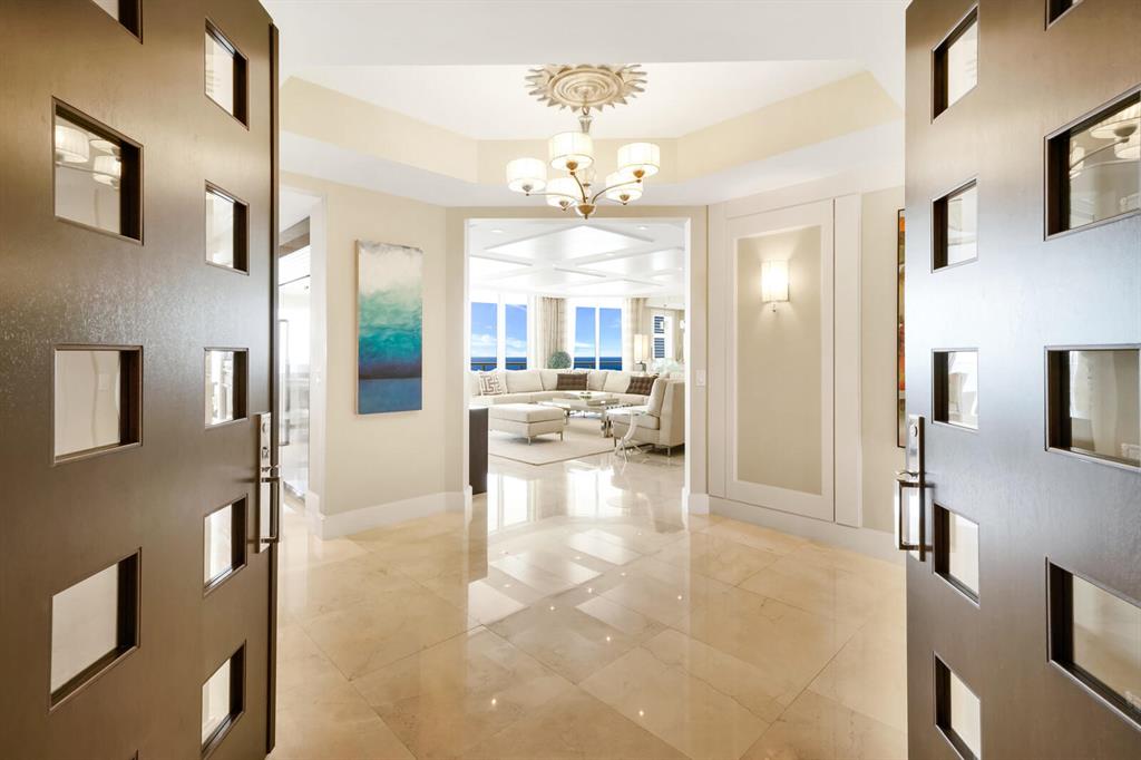 Sweeping panoramic ocean views can be yours! Step into luxury at this 22nd floor condominium at The Ritz-Carlton Singer Island Residences. From, your spacious, private terraces, enjoy sun-kissed views of the Atlantic and the Intracoastal. The floor plan of this luxe residence offers a 3BD/3.5BA plus a den and formal dining room. Oceanfront opulence abounds in this condo including a private elevator foyer with custom double door entry, 9-foot 4-inch ceilings, polished Crema Marfil marble, exquisite ceiling and wall work, and opulent stonework. A beautiful gourmet kitchen, custom Italian cabinetry, and scenic floor-to-ceiling impact glass sliding doors add to the sumptuous feel of this home. The kitchen features a large granite island with wine cooler, Wolf gas cooktop and oven, Sub-Zero refrigerator, and a Miele coffee center. Relax on your private balcony and take in the panoramic ocean views or partake in all that the Ritz-Carlton Singer Island Residences has to offer, including an oceanfront lagoon-style pool, a poolside resident restaurant, cinema-style theater rooms, and more. The Ritz-Carlton Singer Island Residences is situated on 8.8 acres of private, pristine beach at the southern end of desirable Singer Island. Other amenities include 24-hour concierge service, valet parking, two state-of-the-art fitness centers, boardrooms, a poolside summer kitchen, a library and an oceanfront lobby. This residence is offered with two adjacent parking spaces and extra storage.