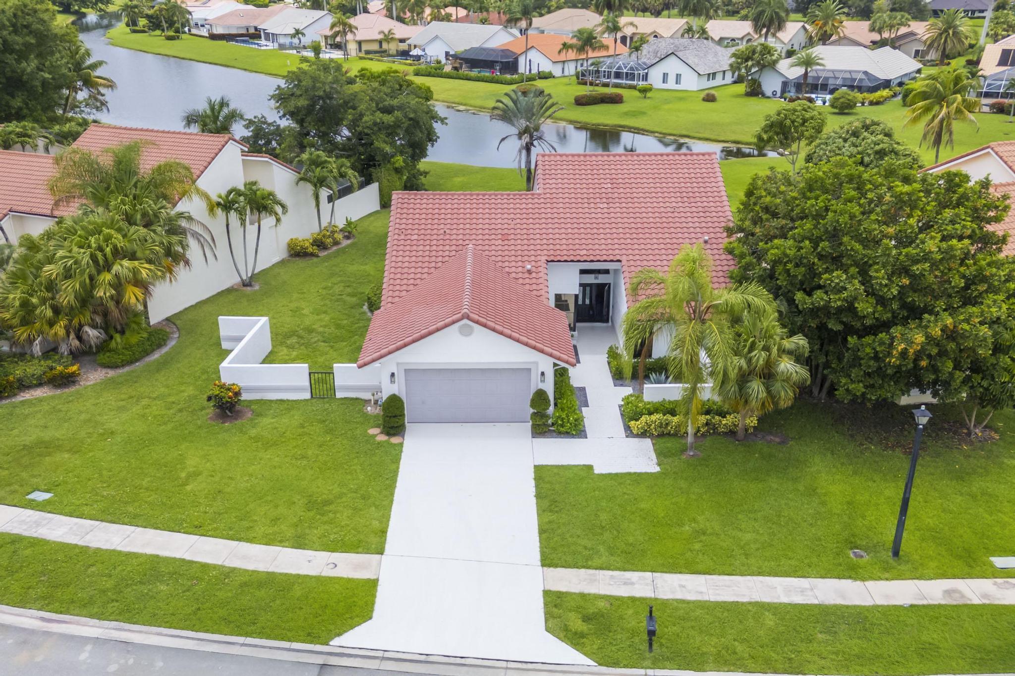 PRICED TO SELL!!!!   Welcome to Boca Greens This beautifully updated 3-bedroom, 2.5-bath single-family home offers an open, spacious floor plan with panoramic LAKE VIEWS from a GENEROUS lot. The home features a freshly painted interior, new wood-STYLE  laminate floors throughout, an  updated open kitchen with granite countertops and stainless steel appliances,  Enjoy the private outdoor built-in round spa/wading tub, perfect for relaxing and cooling off without the maintenance of a full-size pool. Additional highlights include a new A/C, and  a newer washer and dryer.Located in a desirable GATED community close to shopping, HOUSES of WORSHIP, DINING and an A RATED  SCHOOL DISTRICT. This home comes with a beautiful South Florida lifestyle!!!