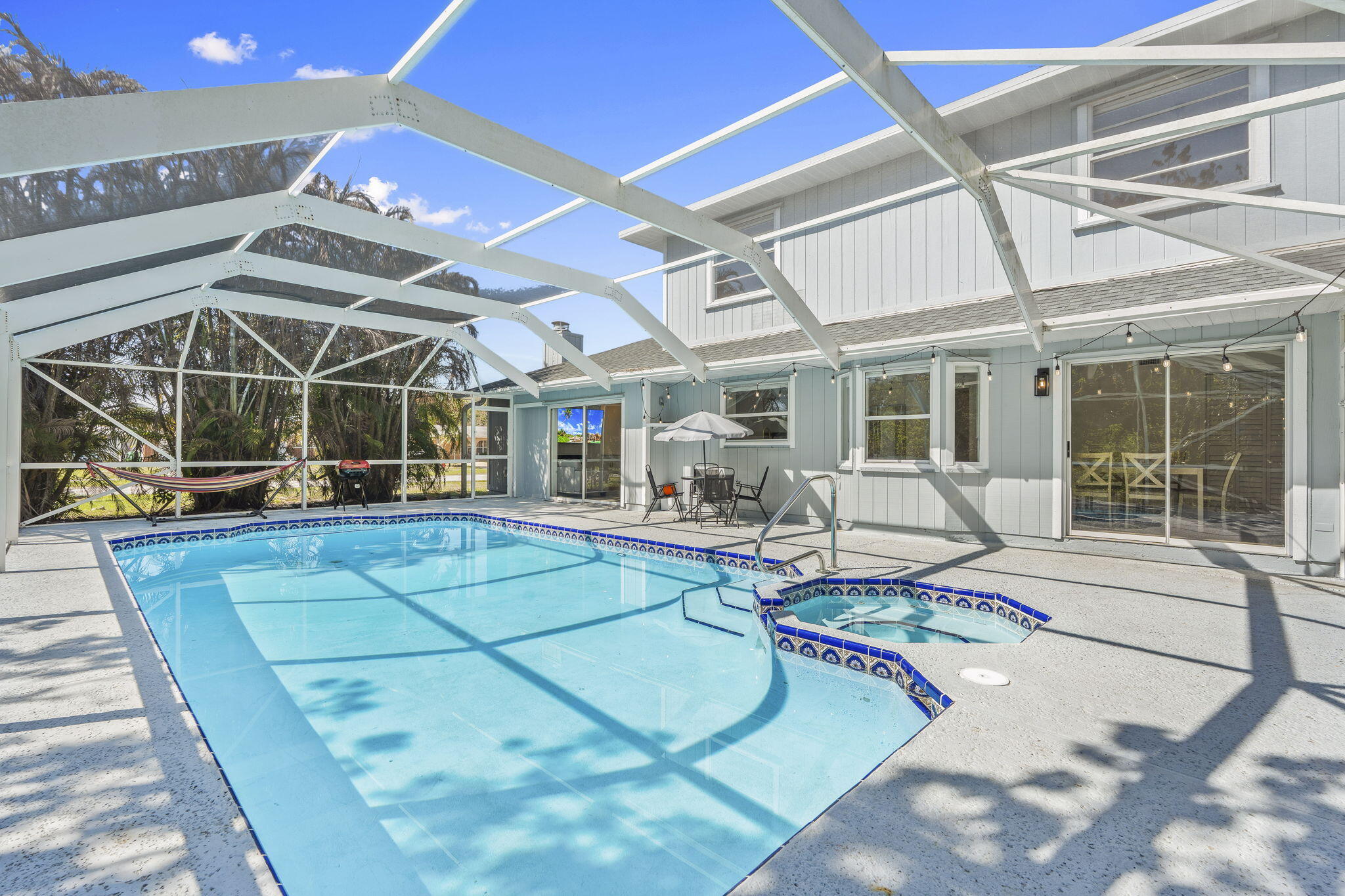 Positioned on a navigable finger of the St. Lucie River with ocean access, this fully updated two story home has 5 bedrooms, 3 bathrooms, a den, and nearly 2,000 square feet of living space, the layout is both functional and flexible for a variety of needs.  The main level includes a bedroom, full bath, and den perfect for guests, a home office, or multi-generational living, while four additional bedrooms and two bathrooms are located upstairs. The living area features a wood burning fireplace with a modern design, and cabinetry on each side.  Recent 2025 upgrades include a new roof, A/C system, and water heater, providing peace of mind for years to come on the big ticket items. The interior has been thoughtfully modernized with soft close cabinets and quartz countertops in both the kitchen and bathrooms.  Situated on an oversized 16,000 sq ft corner lot, the outdoor space is designed for both relaxation and entertaining, featuring a private pool, screened-in patio, and a partially fenced yard.  Conveniently located just 10 minutes to the Florida Turnpike, 15 minutes to I-95, under 10 minutes to shopping and dining at St. Lucie West, and less than 20 minutes to Tradition. Beaches are approximately 25 minutes away, making this home a rare opportunity to enjoy waterfront living with easy access to everything the Treasure Coast has to offer.