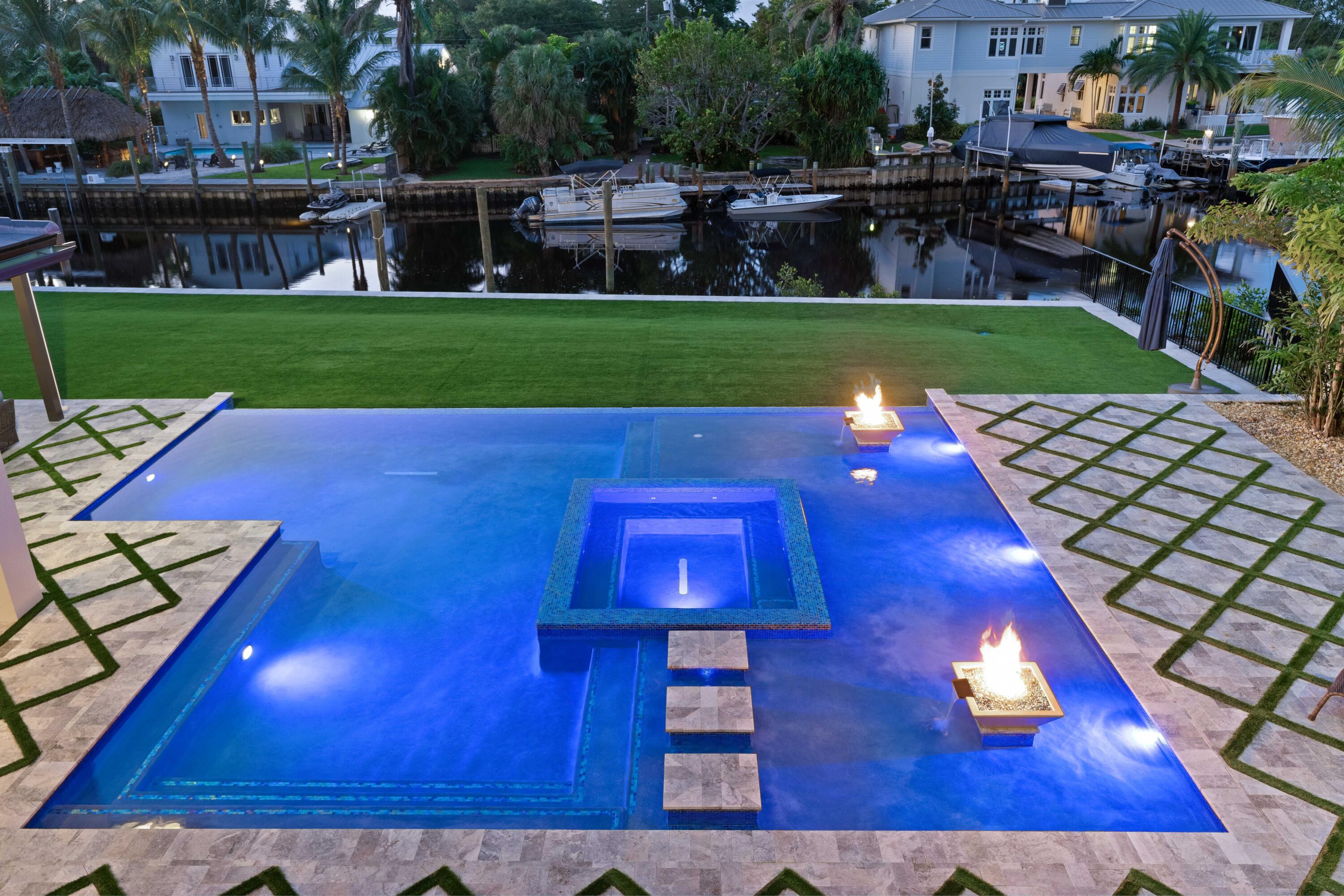 Experience unparalleled waterfront luxury at 261 Old Jupiter Beach Road in prestigious Jupiter, Florida.  This immaculate 2019-built waterfront estate home offers direct ocean access and breathtaking views of the iconic Jupiter Lighthouse—a rare combination that defines true South Florida coastal living. Spanning approximately 7,000 square feet, this meticulously designed 6-bedroom, 7.5-bath residence is the epitome of refined elegance and effortless entertaining.  Step into a world of sophistication where every detail has been curated to perfection. The expansive floor plan features dual grand master suites (one on the first floor and one on the second), dual laundry rooms, and sweeping water views from nearly every room. Custom millwork, a state-of-the-art home theater, and countless high-end upgrades create an atmosphere of understated luxury.  The backyard is a true showstopper—purpose-built for unforgettable gatherings. Center stage is a stunning saltwater infinity-edge pool with fire features, floating steps leading to a sunken spa, and a dramatic poolside water and fire wall. Whether hosting sunset cocktails or lively poolside parties, this outdoor oasis delivers resort-style living right at home.  Additional highlights include a whole-house generator for peace of mind and a deep water dock that easily accommodates mega yachts and large sportfishing boats. With no fixed bridges and just minutes to the Jupiter Inlet, this is a boater's and fisherman's dream come true—offering effortless access to the Atlantic Ocean and world-class fishing grounds.  Perfectly positioned in one of Jupiter's most sought-after waterfront enclaves, this exceptional estate blends privacy, prestige, and an unbeatable location. Live the South Florida lifestyle you've always envisioned—where every day feels like a vacation.  Don't miss this rare opportunity to own a turnkey waterfront masterpiece.