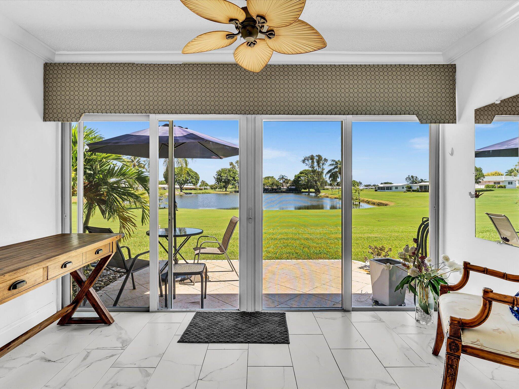 The sun is shimmering on the lake, and you're enjoying your evening cool beverage after a fun day of Golf at no additional charge, and now you're relaxing  in complete peace!  Updated Kitchen and bathrooms and freshly painted  2 bedroom 2 bath villa in Palm Beach Leisureville is what you've been looking for. Peace of mind and economy come with the impact glass, double-glazed windows.  New hot water heater July 2026! Easy maintenance tile throughout, including the enclosed patio.   The beautifully updated kitchen is both elegant and functional, featuring rich wood cabinetry with decorative glass display doors, convenient pull-out drawers, striking black marble countertops, and abundant storage—making it a wonderful place to prepare meals while remaining  connected to the home's inviting living spaces. Both bathrooms have been transformed into spa-inspired retreats with stylish vanities, dramatic floor-to-ceiling wave décor tile, frameless glass-enclosed showers, and luxurious multi-spray shower systems. • Spectacular lake views from the living room, enclosed Florida room, and primary suite • Peaceful waterfront location with exceptional privacy • Impact-rated double-glazed windows throughout • Elegant marble flooring throughout • Crown molding and paddle fans • Beautifully renovated kitchen with wood cabinetry, glass display doors, pull-out drawers, and black marble countertops • Two designer-updated bathrooms with luxury finishes • Full-size washer and dryer inside the home • Updated electrical panel • Assessment paid in full • Recreation lease paid in full  Located within Palm Beach Leisureville, one of Boynton Beach's premier active adult communities, you'll enjoy three clubhouses, heated pools, an 18-hole par-three golf course, fitness center, numerous clubs and activities, and beautifully maintained grounds—all while returning home each day to the quiet serenity of your own waterfront retreat.  This is more than a beautifully updated home—it's a lifestyle defined by comfort, tranquility, and the simple pleasure of living on the water. The low $483 monthly maintenance fee includes Building Insurance, Exterior maintenance, Roof maintenance, Lawn care, Cable TV, GOLF at no no additional fee!, 3 clubhouses, 3 swimming pools, Reserve funds, On-site management, Assigned Parking, activities and roving security.
