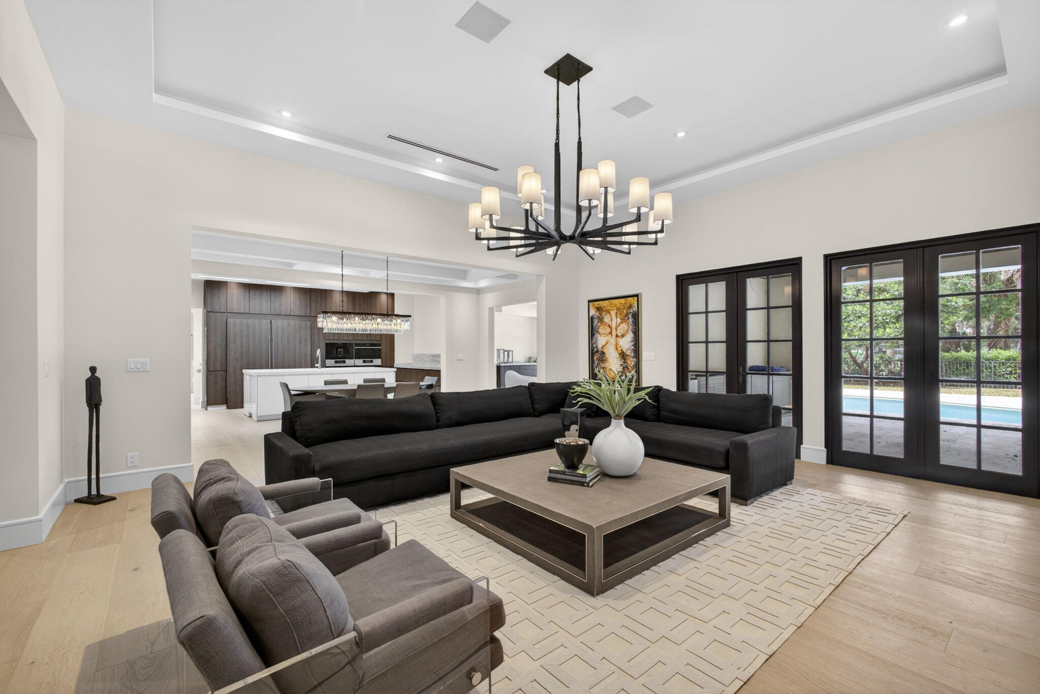 Located within the exclusive Burwick enclave of PGA National, this exceptional residence has been completely re-envisioned and transformed, featuring an all-new floor plan, elevations, and an impressive 955 square foot addition—resulting in a spacious 4-bedroom, 3.5-bathroom home that feels entirely custom and brand new. The exterior is as striking as the interior, showcasing rich mahogany impact windows, a brand-new roof, and a dramatic marble pool deck surrounding a fully redesigned resort-style pool with a luxurious tanning ledge—perfect for entertaining or quiet relaxation in a private setting. Inside, the home features custom Italian cabinetry paired with stunning Taj Mahal quartz, brand-new appliances, and imported European wide-plank hardwood floors throughout. The open-concept  layout is both sophisticated and functional, enhanced by a stylish club room, dedicated media room, and a thoughtfully designed split-bedroom plan that offers exceptional privacy for both owners and guests. This is a rare, must-see renovation that sets a new benchmark for luxury living in PGA National—where vision, craftsmanship, and design come together flawlessly.
