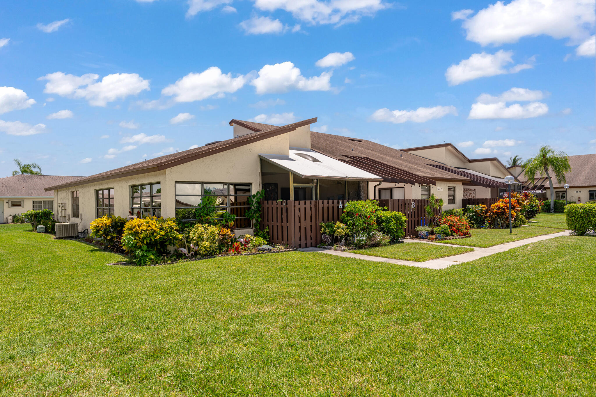This pristine 2-bedroom, 2-bathroom gem features a versatile bonus den and unparalleled privacy with absolutely no neighbors to your right. Step inside to find gorgeous laminate flooring, modern recessed lighting, stainless steel sink, and a beautifully renovated bathroom. Love the Florida lifestyle? Your private, tile-floored covered patio is fully wired for outdoor TV viewing—perfect for game days or relaxing evenings overlooking the garden. Enjoy ultimate peace of mind with a 2018 roof and 2020 water heater. Packed with storage (including attic access and an outdoor garden shed), an in-unit washer/dryer, and roll-down window coverings. HOA covers water & cable! Amenities of the community pool, tennis courts, and clubhouse, all just 10 minutes from busting Downtown Delray Beach.