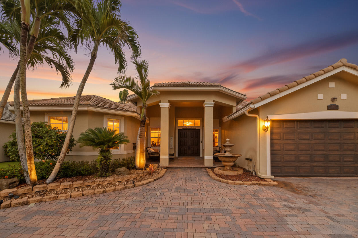 Welcome to a beautifully updated Wellington residence that blends comfort, style, and effortless Florida living. From the moment you arrive, the home makes a lasting impression with its inviting entry, elegant finishes, and light-filled interior spaces designed for both everyday living and entertaining. Inside, you'll find a warm and polished layout featuring a dedicated office with rich built-ins, an elegant dining area, and comfortable living spaces that flow naturally toward the outdoors. The fully updated kitchen and main living areas feel fresh, bright, and sophisticated, with crisp cabinetry, modern lighting, and a clean, contemporary feel throughout. The living room offers a high end home theater. Thoughtful upgrades add major value and peace of mind including a full home generator. The home also offers spacious bedrooms, a beautifully organized walk-in closet, and refined details that create a move-in-ready atmosphere.  Step outside to enjoy your own private backyard retreat, complete with a covered patio, sparkling pool and spa, expansive paver deck, outdoor kitchen area, and serene views of the surrounding water and lush green space. Whether relaxing poolside, hosting guests, or enjoying quiet evenings outdoors, this home captures the best of Wellington living in a picturesque setting.