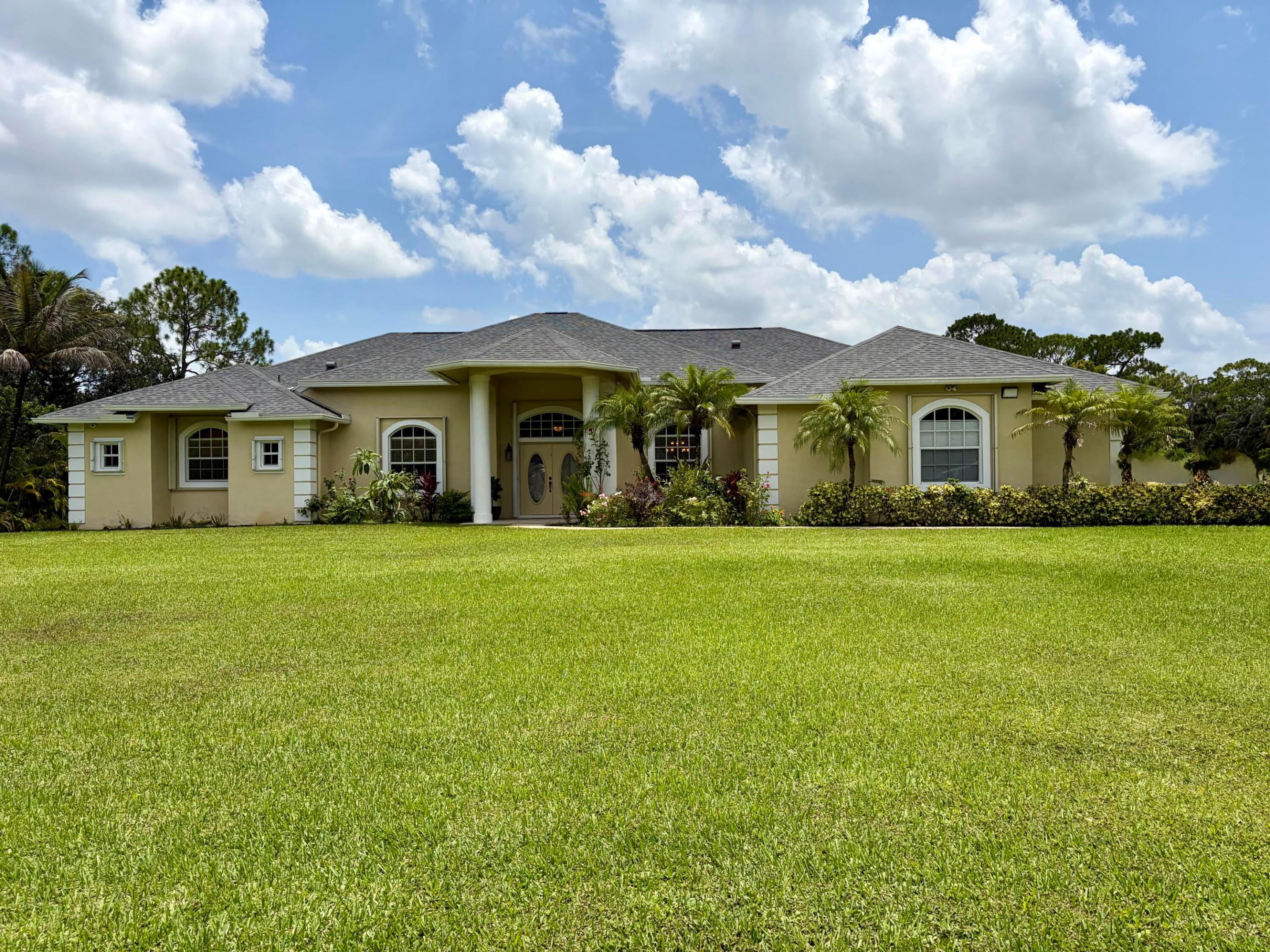 Exceptional 4-BR, 3.5-bath Pool home with No HOA offering an impressive 3,722 sf of living space on 1.29 acres of fully fenced property. NEW ROOF 2025. This Acreage home offers comfort and convenience with a 2-car garage, concrete driveway, screen enclosed salt water pool, and a cozy fireplace that adds charm to the main living area. Soaring ceilings and crown molding enhance the spacious feel. Oversized primary BR with spacious office/flex space.  The kitchen features granite countertops, stainless steel appliances, and ample cabinetry, perfect for entertaining, and surround sound throughout the home. Accordion shutters provide added protection. Mature fruit trees in the expansive yard. Bring your boat or RV.  A rare opportunity to own a private oasis with space to live, play and grow.