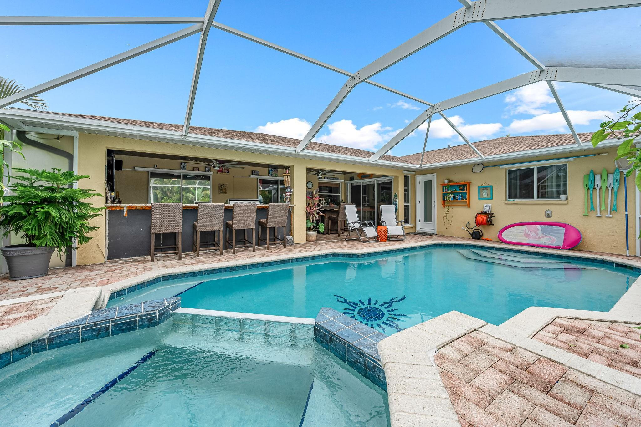 SHORT SALE POOL home off Surfside Blvd in the desirable waterfront area. Present Highest AND Best Offer by Sunday April 26th @ 6:00 PM. This home has custom Thomasville soft close cabinets, quartz countertops, new Kitchen-aid and GE appliances including double stove. It has beautiful tile flooring throughout, custom ceiling in foyer, The large master bath features include his and her closets, a soaking tub and a large walk in shower. The pool bath has a new walk in shower with beautiful tile. The back patio oasis has a large built in kitchen with granite countertop, beautiful heated pool and jacuzzi with a brand new pool heater, custom wood ceiling in covered area of Lanai, surround sound system with a 75" flat screen TV and a screened in lanai for your outdoor entertaining.