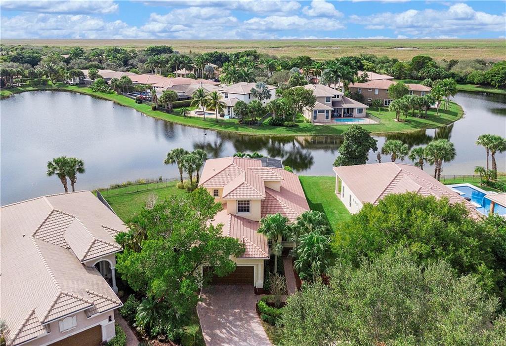 Beautiful 5 bedroom, 3 bath home on large pie shaped cul-de-sac lot in Heron Bay! Heated pool & spa w/ screened in patio w/ amazing lake views. This home has volume ceilings throughout main living areas plus upgraded fixtures, fans & window treatments.  Gourmet kitchen w/stainless steel appliances and granite tops.  Custom built out closets in Master Bedroom. Private lot w/ outdoor space that's perfect for entertaining & huge fenced lot to play on next to the pool! Other features include tile and laminate flooring throughout w/ no carpet, accordion shutters & freshly painted. Heron Cove includes lawn service. Gated community w/ 2 clubhouses, pools, tennis courts, kids splash areas, social activities & much more. Backyard facing west w/ beautiful sunsets over the lake.