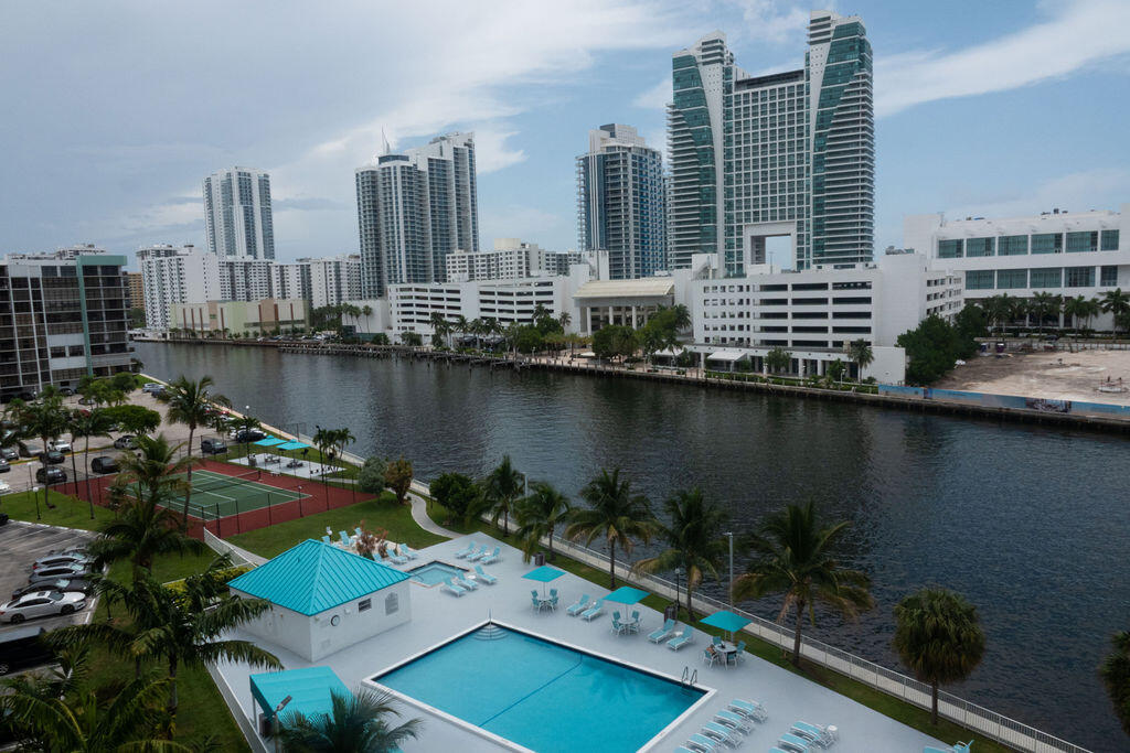 This charming condo in desirable Hallandale Beach has the view you have been looking for! Sit on your balcony overlooking the pool and Intracoastal water way and watch the boats go by. This eastern facing unit has floor to ceiling windows in the main bedroom, den and family room areas. The open kitchen with granite counters and stainless steel appliances overlooks the family area. One large spacious bedroom contains a large walk in closet with plenty of room for extra storage. A separate den offers extra living space.  This full-service building, located in the popular Three Islands, offers an array of resort-style amenities, including 24-hour security, concierge, valet service, a state-of-the-art fitness center, sauna, pool, tennis courts, media room, billiards room, and BBQ area.  The condo also includes two assigned parking spot and allows for two pets. Recently installed hurricane windows and glass sliding door protect your investment. Condo fee includes cable, water and internet. Washer and Dryer allowed to be installed. 40 year complete. Extra storage area in laundry room included.  Note that new ownership cannot rent for the first 18 months, but leasing is permitted after that period.  The condo also includes two assigned parking spot and allows for two pets. Recently installed hurricane windows and glass sliding door protect your investment. Condo fee includes cable, water and internet. Washer and Dryer allowed to be installed. 40 year complete. Extra storage area in laundry room included. Note that new ownership cannot rent for the first 18 months, but leasing is permitted after that period. Located near beautiful beaches, shops, dining, and a dog park, this condo is priced to sell and easy to show. Don't miss out on this incredible opportunity!