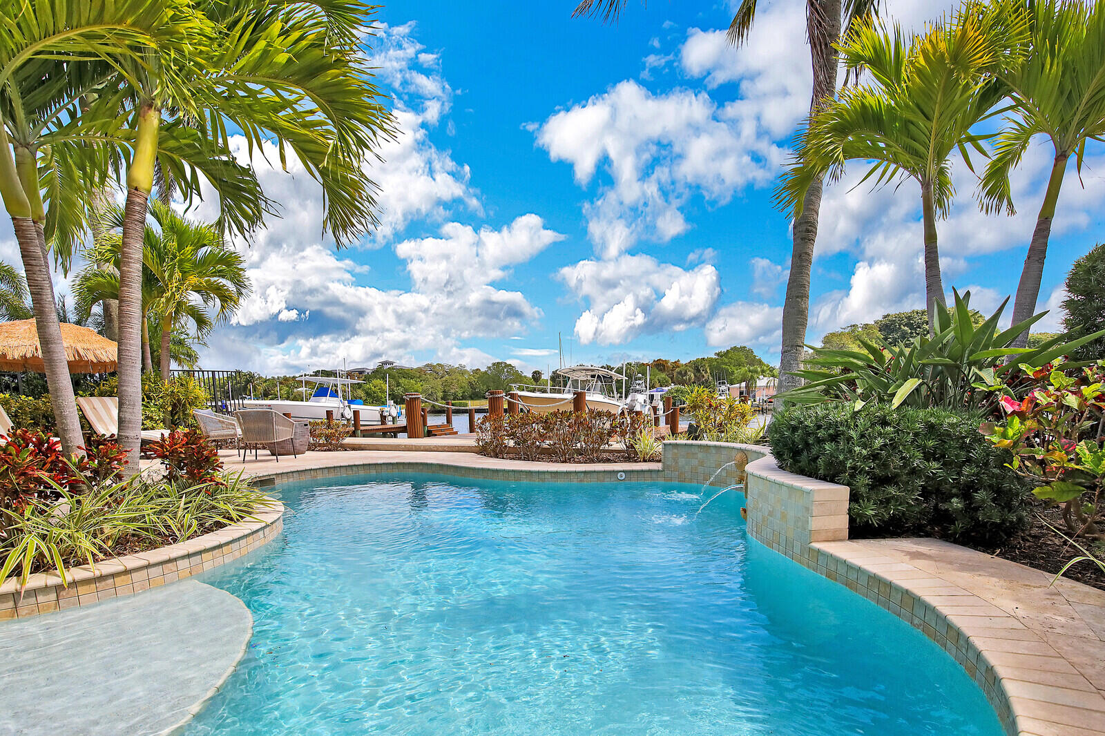 Immaculate, designer decorated, direct intracoastal home features panoramic water views, dock with 16,000 lb boat lift, and a newer heated pool surrounded by Travertine patio decking. 
 Remodeled kitchen with quartz counters and 5 burner gas range & double ovens. Water views from both the front and back of the home.  All windows & doors replaced with hurricane impact in 2019. Downstairs master bedroom features his/hers walk in closets and volume ceilings. Master bathroom has a glass block walk in shower, large roman tub and double vanities. 
Plantation shutters throughout. Adjacent to the master bedroom is an office with custom wood built-ins and pocket doors for privacy.
The 3 bedrooms upstairs all have walk-in closets and all have a balcony to enjoy the water views  both front & back
