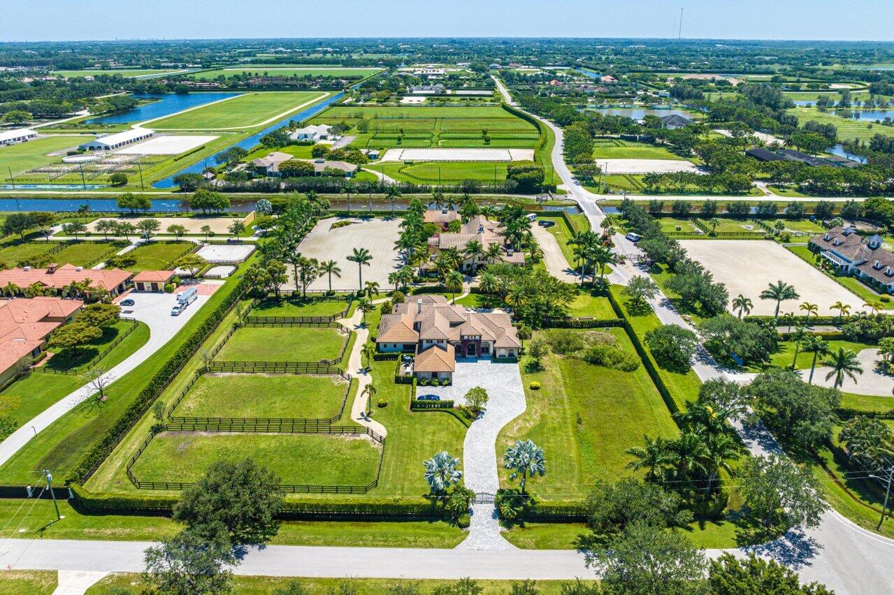 Exclusive, Idyllic and extremely private resort-like setting will capture your heart from the moment you step onto this exquisite Equestrian property! Ideally located in the enclave of Palm Beach Point and surrounded by the newest, most high-end farms, this property is destined for a discriminating professional Trainer/Rider or a fully immersed Equestrian Family whose dedication to their sport is rewarded by a luxurious, amenity-filled home that provides  ''Zen-like'' serenity for one's complete comfort.  This private oasis offers respite from the everyday stressors of showing and working horses ~ Just because your workday is hard, doesn't mean your home life needs to be too!!  So many details to share in this limited space, so please review the ''More'' Tab & the attached Documents. This meticulously maintained home features a completely renovated (down to the studs in 2020) 6 bedroom, 5.5 bath main house that is designed to provide a serene atmosphere where living means relaxing in complete comfort and modern style!  The 2 story residence provides 4 spacious main level bedrooms and 3.5 baths, along with a 2nd floor that adds 2 additional generous bedrooms, 2 full baths, and an impressive, newly added Home Media room which sports a state of the art surround sound system built to entertain!  

The incredible gas powered kitchen boasts top of the line everything with double ovens, dual refrigerators and dishwashers, plus offers picturesque views overlooking the heated salt-water pool and spa...wander into the expansive living room and your attention will be immediately drawn to the spectacular outdoor kitchen and entertainment area designed to delight the "Chef" in all of us!  This area is a main attraction for everyone and is delightfully pleasing for any daytime or evening entertaining; with its expansive bar area, motorized roll-down screens, tasteful accent lighting and top of the line grilling stations (a huge gas grill AND a Big Green Egg), owners will want to spend all their free time here!  Whether hosting large groups or just an intimate gathering with family and friends, this ambience of this outdoor living space makes you feel like you have a private resort in your own backyard.

The entire property features Impact windows and doors for storm protection on all buildings, plus a whole house backup Generator and a 1000 gallon Reverse Osmosis Water system to supply exceptional water quality throughout the main home!  The Guest House and barn both offer separate Water filtration systems to each.  In today's world strong and reliable Wi-Fi is required and this property features Fiber Optic Cabling directly hard wired by AT&T into the Utility Box to the main home, guest house, barn and freestanding Gym!  

Additionally, you won't have to worry about any water retention or drainage issues as this property has been re-engineered to integrate exceptional drainage improvements and underground drainage infrastructure additions, keeping this farm "high and dry" always!

Not to be forgotten, the magnificent 12 stall barn offers tremendous airflow throughout with its 4-winged design, large stall windows with storm shutters and roll down shutter protection on each of the four entryways.  The barn hosts 4 covered interior wash stalls, a spacious tack room, plus 2 large storage rooms (with A/C) for Feed Storage and equipment.  Additional amenities include a large 1 bedroom Apartment, a separate laundry room and a 2nd rider bathroom.  

A tremendous amount of parking for any number of cars, trucks and large trailers surrounds the barn with a high-end pea rock driveway that also leads to all the paddocks as well!

The impressive arena measures a generous 250' x 130' and includes a large bank on one end for improved exercise and training of your horses.  The sand and fiber ring offers exceptional footing with great drainage, key for any Equestrian. The arena was installed and is maintained by Bruce with Equestrian Footings and is worked with a Dragonfly 4 in 1 Pro Tractor and Drag.  The farm also has 4 large paddocks (could easily become 5-6) a Horse Treadmill (lightly used) and the barn entrance leads you directly out the back gate of Palm Beach Point for easy access to the Showgrounds as well as remote In & Out access of the PBP Community without having to access the front Guard Gate.

The main home was built in 2005 and completely renovated from top to bottom in 2020, plus expanded by over 400 additional sq ft Under Air.  In 2010 the prior owners built a 3/2 guesthouse on the property, plus built the 12 stall barn, ring, paddocks and the stand-alone Gym adjacent to the barn.  

The pool was added in 2014, and then the extended covered patio and outside kitchen was added in 2017 to complete the resort-like amenity additions that make this property both luxurious and a pure pleasure to enjoy on so many levels!  The Total Living Sq Ft of the entire property rounds out at 8,331 under air while the Total Sq Ft measures 17,830 as permitted and recorded in PBC Appraiser's Office.

Exterior lighting, irrigation and septic updates have all been made  over the past year along with the addition of the main home's Media Room.  The Documents Attached to the Listing will provide further details about the property.
