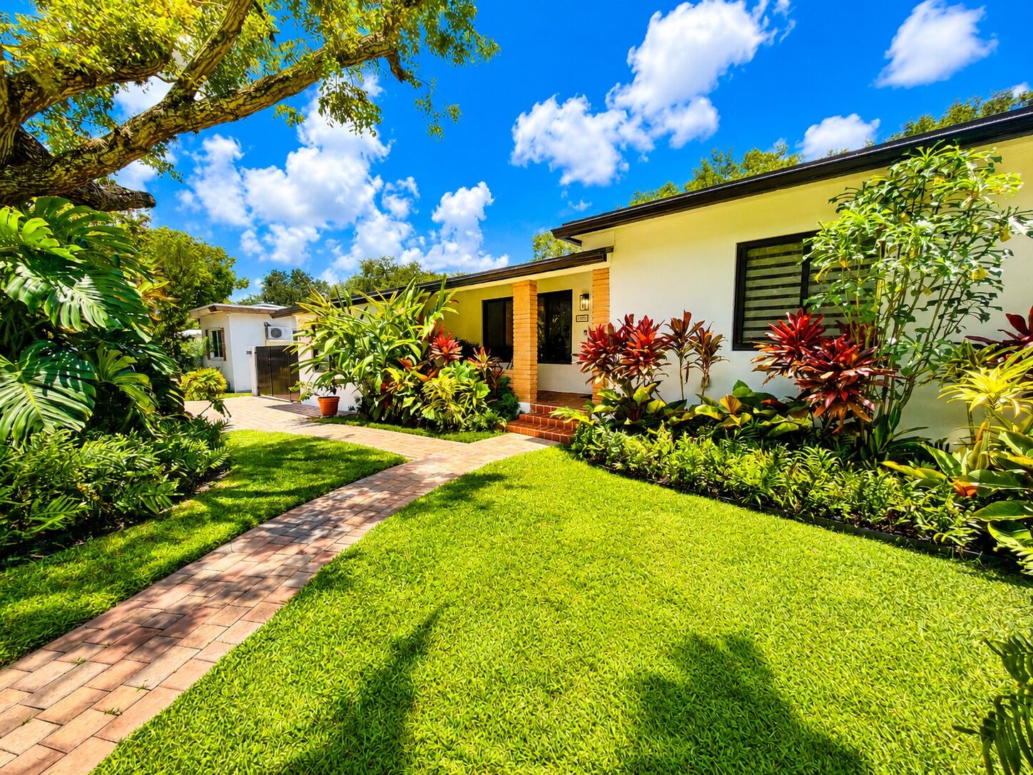 Beautifully updated tropical oasis featuring major upgrades throughout! This move-in ready home offers a new roof (2023), hurricane impact windows (2023), central A/C (2020), new well, new 300-gallon septic tank (2023), new sprinkler system, new soffit, and an additional exterior electrical panel for added convenience and functionality. The renovated kitchen was updated in 2023 with modern finishes and new appliances, along with a new LG stackable washer and dryer (2023). Bathrooms have also been updated with new fixtures and appliances. Outdoor living is a dream with a new Trex deck, newly completed brick paver driveway, and a new gate creating excellent curb appeal and entertaining space. The lush backyard is filled with mature tropical landscaping and fruit trees including coconut