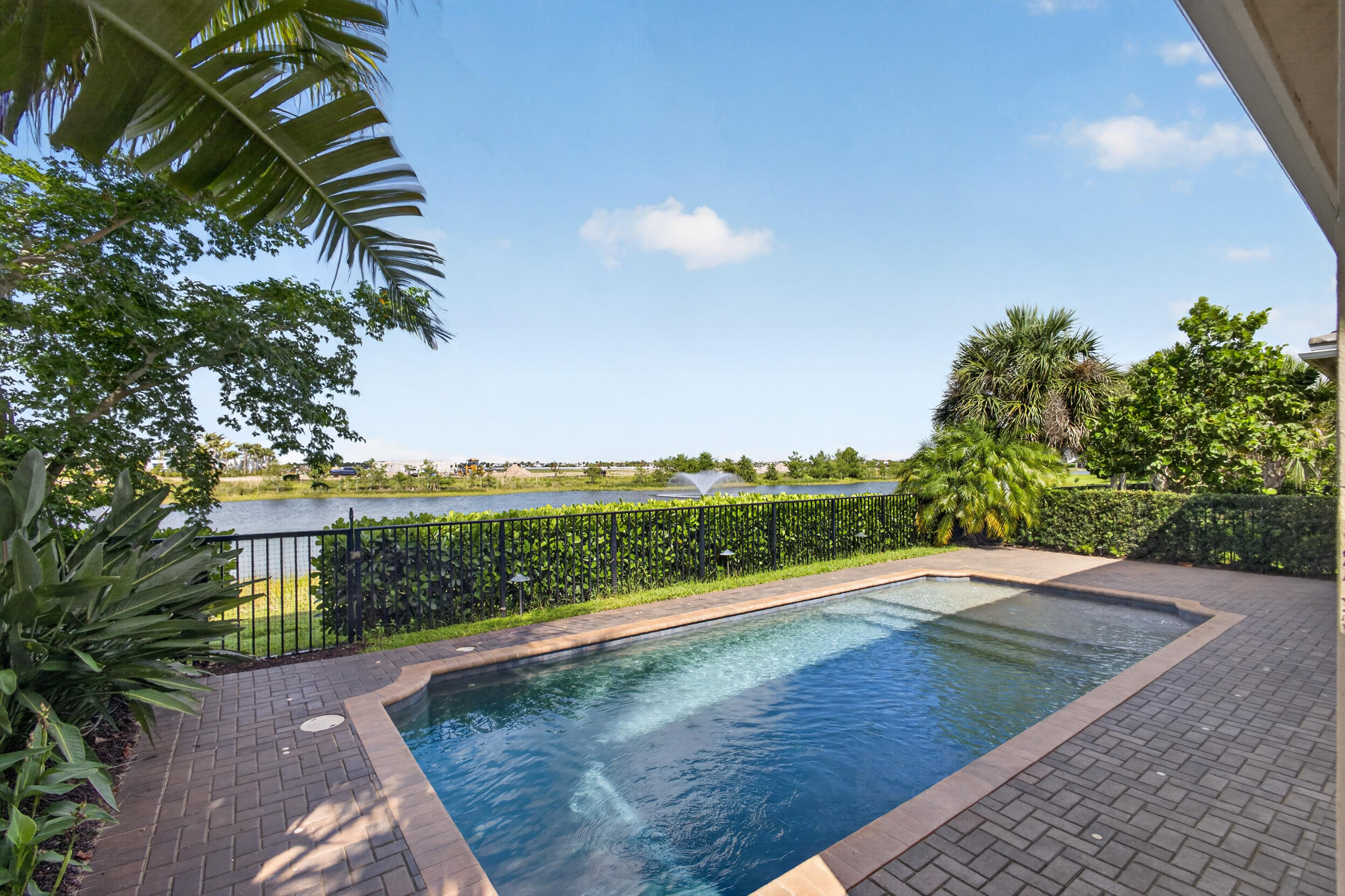 Beautifully landscaped pool home with breathtaking southwest sunset and water views in Regency at Avenir, a gated 55+ community in Palm Beach Gardens. This McKenna Transitional offers a desirable triple-split layout with 3 bedrooms, 3 baths, den/office, and flex space. A 16-ft slider opens to a covered lanai with electric screens, allowing the space to live open or enclosed for seamless indoor-outdoor living with the heated saltwater pool. The expanded primary suite features private lanai access, two finished walk-in closets, including one with direct laundry access. Highlights include an 11.6 kW solar array, 22 kW whole-house generator, water softening system, and spacious 2.5-car garage. Within short distance to The Pearl clubhouse, amenities, and sport courts. Rare McKenna offering.