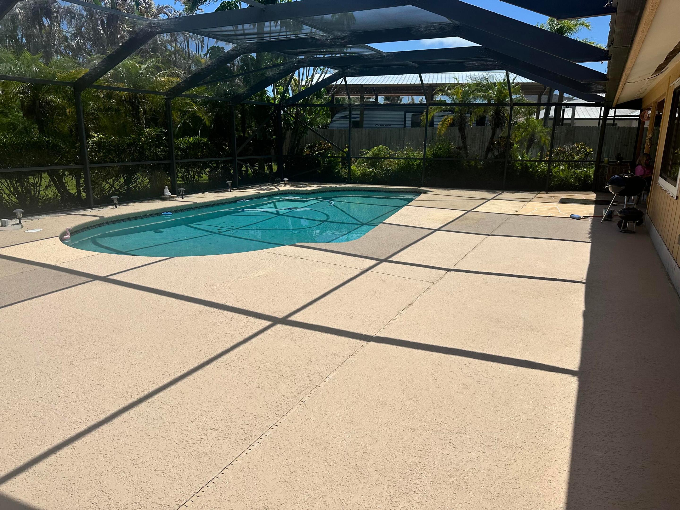 Steal me now!!!  Located in desirable Jensen Beach area on a lot just over 1/2 acre.  No rules and regulations in this area.  Peace and Quiet for your enjoyment. The home has a split plan perfect for extended families and a large oversized pool.  Just to make it more desirable, there is a new galvalium roof guaranteed for 25 years plus solar panels to guaranty low electric bills.  The oversizeed garage easily fits 2 cars and possible golf cart. Minutes to Ocean beaches, downtown Jensen Beach Thursday night Jammin Jensen and restaurants and shops.  Able to see most any time. Call for appointment and make this the home of your dreams!! Solar panels can be paid off at closing by the seller.