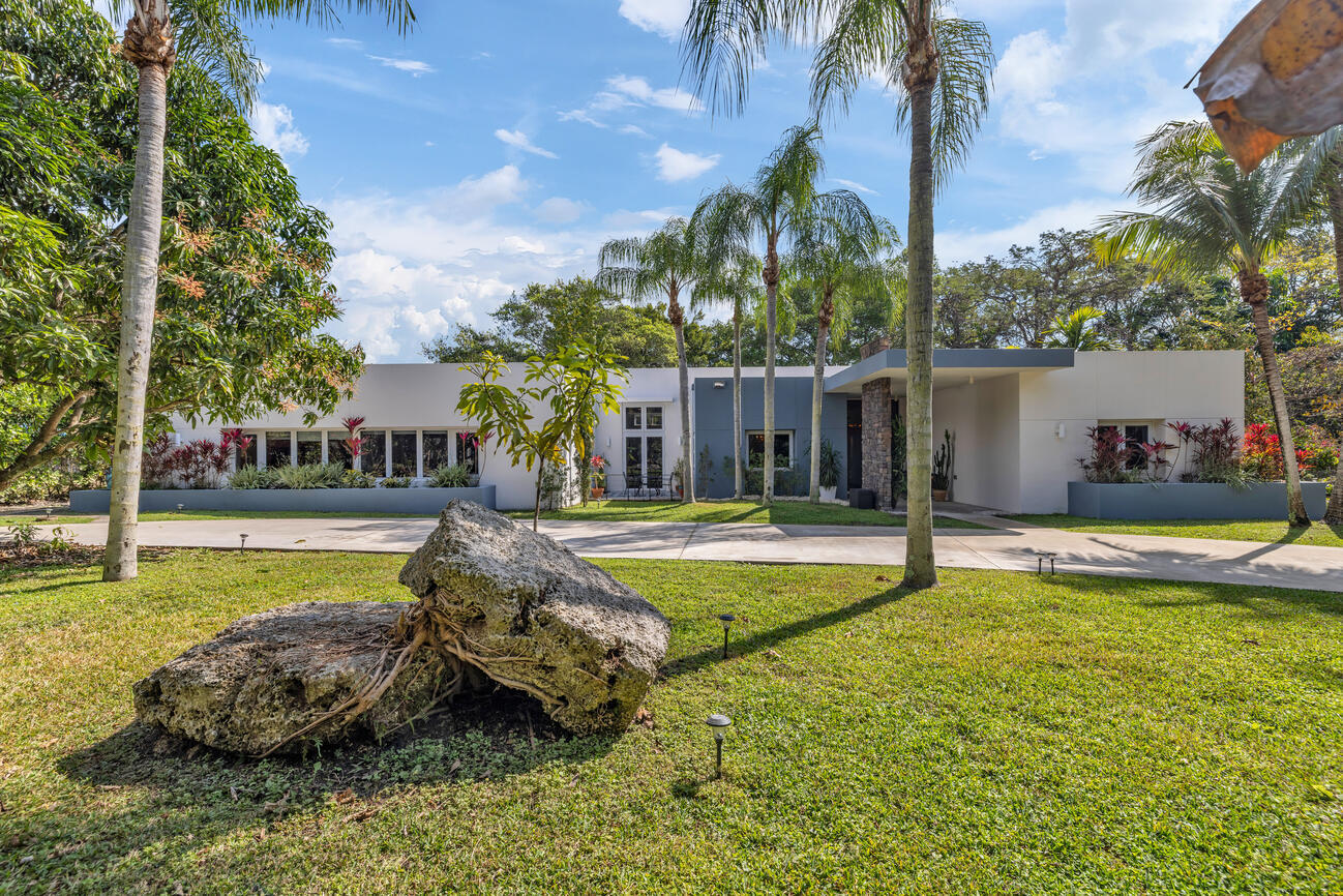 Spanning 6,293 total square feet, including 4,844 square feet under air, this residence offers expansive indoor living complemented by generous covered outdoor spaces. Set on a 1.05-acre agriculturally zoned lot in East Kendall, the exceptional property features a 4-bedroom, 4-bath main home. In addition, there is an approximately 900-square-foot detached 2-bedroom, 1-bath guest cottage, which is not included in the total or living square footage. This structure is not permitted and is being conveyed as a bonus space. Buyer shall perform their own due diligence regarding its use, legality, and future improvements.  Built in 2012 with hurricane-resistant concrete construction, the main home features 12 to 14-foot ceilings throughout, impact-resistant windows and doors, and.. ..a whole-house generator. The open-concept great room flows seamlessly into a gourmet kitchen, ideal for entertaining and everyday living. The primary suite offers a spacious, spa-like retreat, while modern systems throughout the home provide comfort, efficiency, and peace of mind.  The expansive grounds are designed for versatility. Currently outfitted with a 3-stall barn, the property is well-suited for horses, hobby farming, or agricultural use. Alternatively, the land easily accommodates a resort-style backyard with room for a custom pool, pickleball or tennis court, basketball court, large gardens, or a fully personalized outdoor oasis. A 1,000+ square foot covered patio overlooking mature landscaping with fruit trees enhances the outdoor living experience.  Tech-forward, secure, and sustainably built, this East Kendall estate delivers the rare combination of land, privacy, flexibility, and accessibility. Located close to shopping, dining, and major routes, this is a unique opportunity for buyers seeking long-term value in one of Miami's most desirable residential areas.