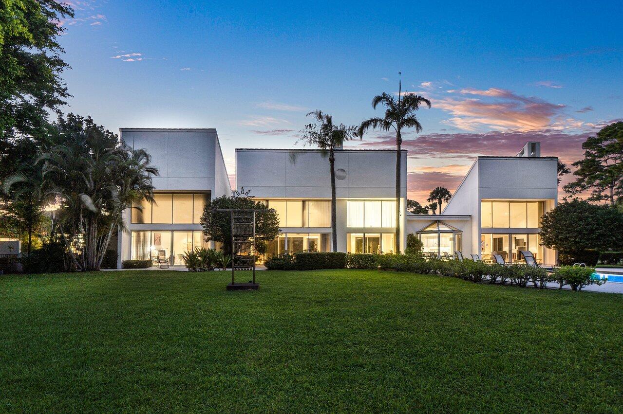 Located in The Enclave - An Exclusive gated community within the Breakers West Country Club. This property has Sherle Wagner's artistic eye and craftsmanship reflected throughout with custom stone hardware, rose quartz bath, Burlwood bookcase, and a floor to ceiling marble fireplace. Designed for privacy, the outdoor tropical oasis has a large, heated pool and dining/ entertaining area overlooking the lake and golf course, situated to feel like your own private estate.