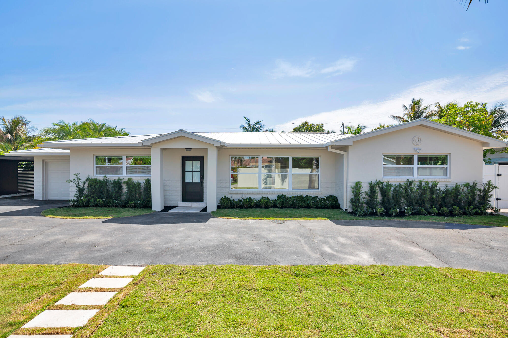 Spectacular, fully renovated, one-of-a-kind 4 bedrooms 4 full baths with one car garage pool home located in the highly sought-after lake community of Lake Clarke Shores—just one block from the public boat ramp! Bring your boat, jet skis, and enjoy the ultimate South Florida lifestyle in this beautifully updated 2026 residence. This exceptional home features a great layout and floorplan including a spacious primary suite and a secondary smaller junior suite overlooking the backyard—perfect for guests or multi-generational living. The interior showcases high-end finishes throughout, including a stunning backlit Cristallo backsplash, natural marble stone in all bathrooms, and elegant herringbone-pattern porcelain wood-look tile imported from Italy spanning the entire home. Additional  upgrades include a brand-new metal roof and natural skylight, filling the home with warmth and natural light. Gas connections are already in place in the backyard, offering the option to add a gas grill to your outdoor kitchen setup. Step outside to an incredible backyard designed for entertaining and relaxation. Enjoy artificial turf, easy to maintain a beautiful tropical foliage around a heated pool with a Jacuzzi, an oversized tiki hut, a fully equipped summer kitchen, and a cabana-style full bath. There is ample space on both sides of the property to accommodate a boat, jet skis, golf cart, or any other recreational toys. This home truly has it all—style, functionality, and an unbeatable location. You won't be disappointed—bring your buyers, this one will NOT LAST!!!  Actual square footage is larger than shown on public records: actual sq ft under air is approximately 2,400 sq ft, and the total square footage is over 3,000 sq ft. All information is approximate and subject to errors and omissions.