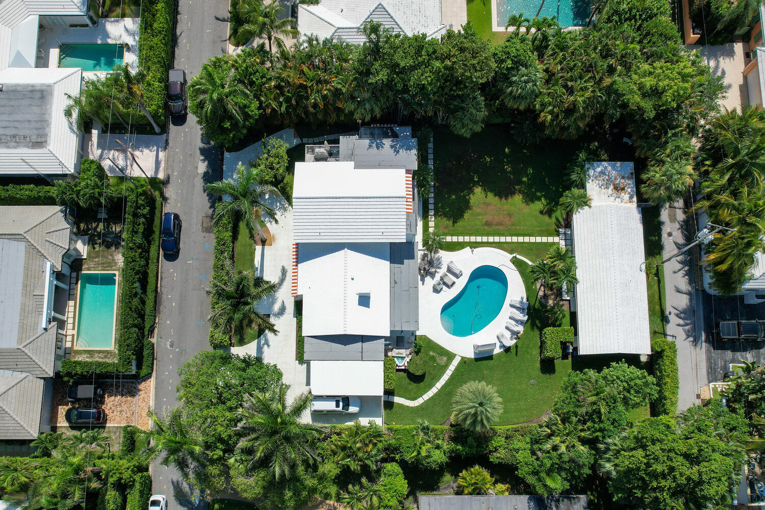A big, beautiful North End property for anyone looking to build new or renovate. Lot is just under 1/2 acre at 20,592 sqft. (125' wide x 165' deep). Via Marila is one of the few north end streets with deeded beach access at one end of the block and Lake Trail access at the other. Main house is 1950 cement block construction with 6 bedrooms, 4.5 baths and 3,700 sqft under air. The Guest house/Garage sits on the Laurian Lane alleyway– it has 2 bedrooms, 2 baths, living room, kitchen, one car garage and 1,050 sqft under air. AC is new as of 2020, cement tile roof is 2014. The house is a rambling, comfortable family home that offers a buyer a variety of options. Live there, lease it, renovate or build new.