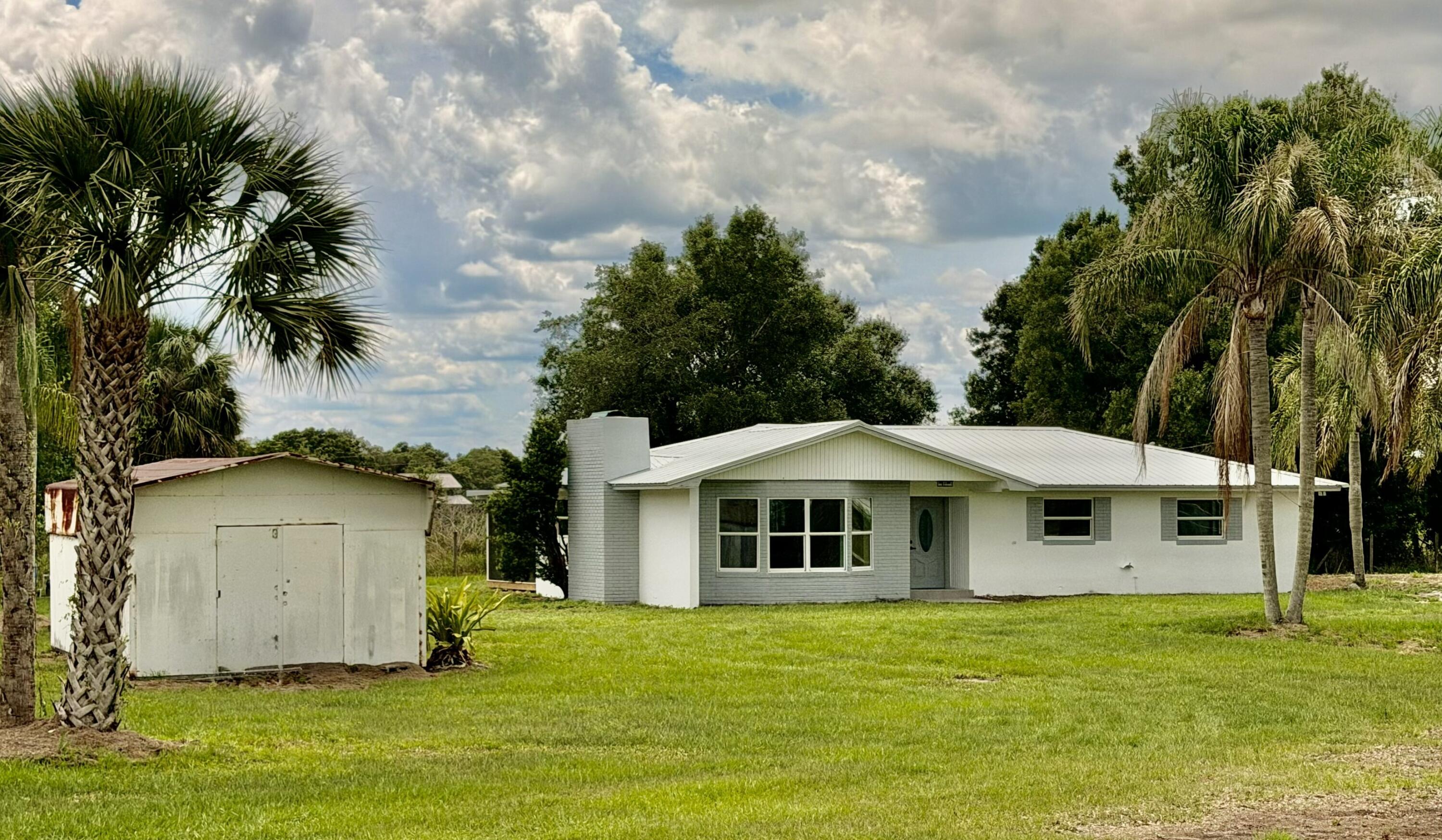 Farmhouse Elegance on 3.5 Acres! Gracious country living in this beautifully remodeled CBS home nestled on over 3.5 acres. Blending timeless farmhouse charm with modern updates, this 3 BD/ 2Ba CBS home offers a warm and inviting atmosphere from the moment you arrive. The welcoming foyer to the stunning sunken living room, highlighted by a cozy fireplace andbay window lighting.. The dining room showcases chair rail molding, judge's panels, stately columns, and distinctive stone accents, creating the perfect setting for gatherings and special occasions. The thoughtfully updated kitchen features solid-surface countertops, shaker-style cabinetry with contrasting hardware, a farmhouse sink, Lazy Susan storage, and new stainless steel appliances. A convenient cabinet door walkway leads to the utility room and pantry for added functionality. Recent improvements provide peace of mind, including newer windows, a newer A/C system, metal roof, tankless water heater (2026), water softener (2026), and a new septic system and drainfield (2026).Enjoy outdoor living from the screened porch overlooking the expansive property. The grand oaks offer serenity and the queen palm-lined driveway creates a memorable entrance. The 28' x 14' shed offers additional storage or workspace. With 3.5 acres of usable land, there's plenty of room for animals, horses, gardens, recreational vehicles, or simply enjoying the privacy and beauty of country living. This exceptional property offers the perfect balance of rural tranquility and modern comfort.  Bring your Dreams—to Reality!   Dimensions are approximate, must measure for exact.
