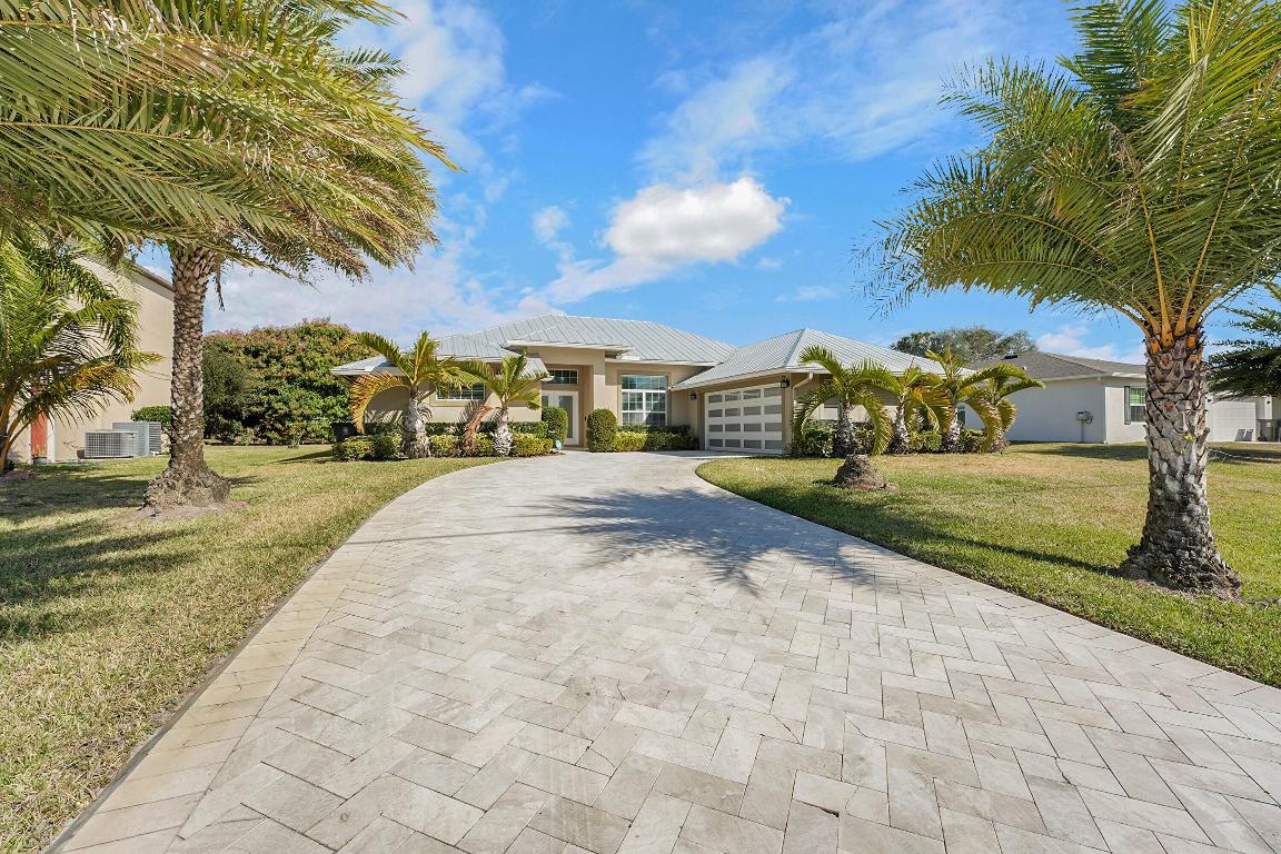 Welcome to this beautifully maintained newly built home that perfectly blends modern design, quality construction, and Florida living. Offering 3 bedrooms, 2 baths, and just over 2,000 sq ft, this residence sits on an oversized lot with a rare expansive yard—ideal for entertaining, play, or future pool potential. Enjoy peace of mind with impact-rated windows and doors, a sleek metal roof, and energy-efficient construction. Curb appeal shines with upgraded landscaping and a custom paver driveway. Inside, the bright open floor plan flows effortlessly, featuring a split-bedroom layout for added privacy. Located in a desirable Port St. Lucie neighborhood with no HOA, this move-in-ready home is an exceptional opportunity. Schedule your private showing today!