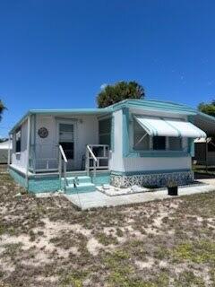 Charming manufactured home in Leisure Village, a well-maintained 55+ community in Stuart. Living room features dark wood laminate floors and ceiling fan. Florida room adds extra living space with tile floors and abundant natural light. Kitchen includes white cabinetry, tile backsplash, black appliances, and dishwasher. Two bedrooms and two bathrooms. Side patio perfect for outdoor relaxing. HOA $275 per month includes water, sewer, lawn care, trash, cable TV, clubhouse, bocce, and shuffleboard.