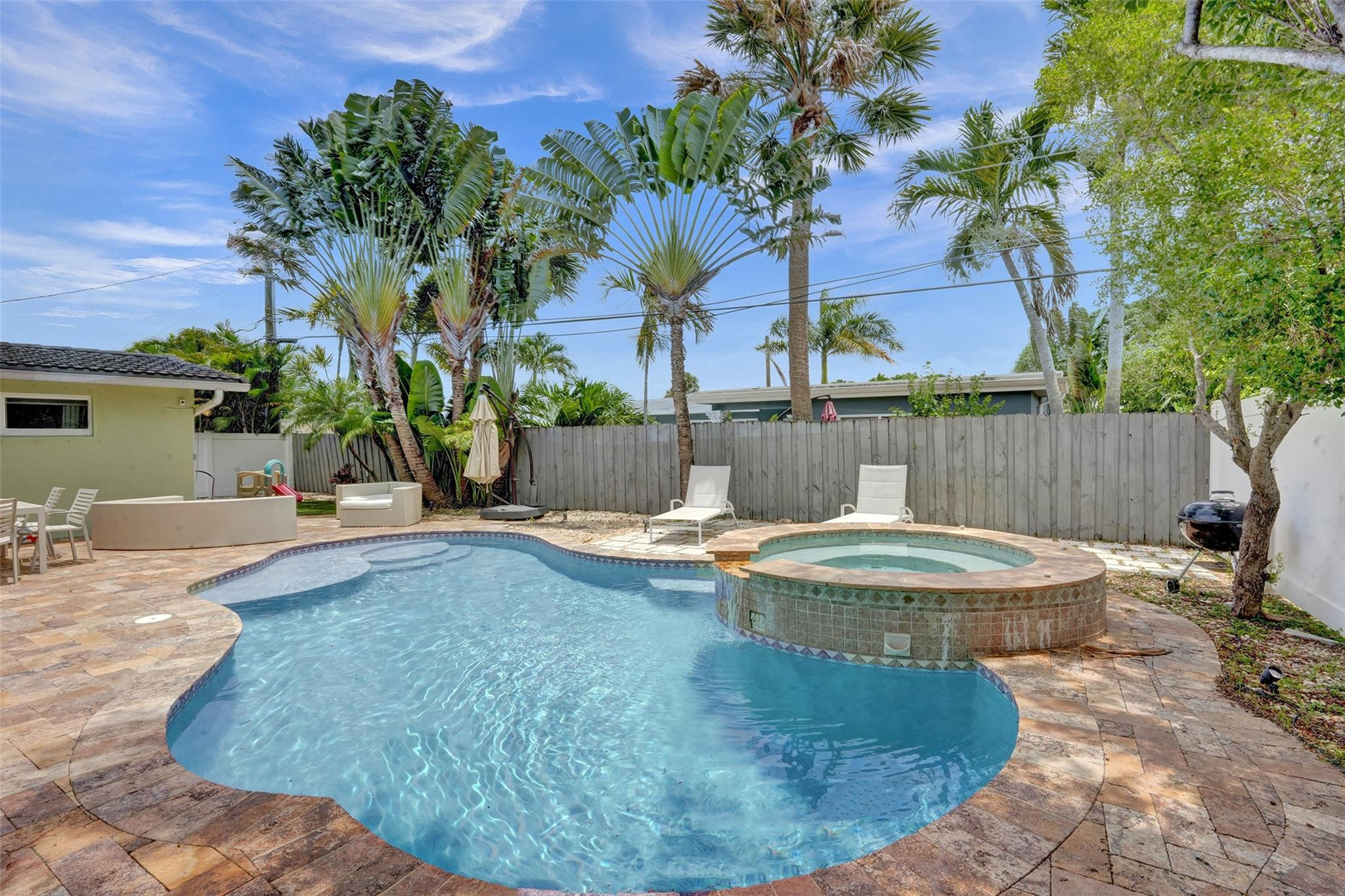 Step into luxury as travertine marble floors welcome you into this stunning 3-bedroom, 2-bathroom home with a refreshing pool. Renovated, the kitchen boasts maple cabinets, high-end stainless steel appliances including a convection oven, and elegant granite countertops. The layout features a split floor plan, offering an airy and expansive feel throughout.Outside, the property is adorned with lush tropical landscaping and Turkish pavers that surround a heated free-form pool and spa, creating a private oasis perfect for relaxation and entertaining.Don't miss out on the chance to experience the quintessential Florida lifestyle at its finest.