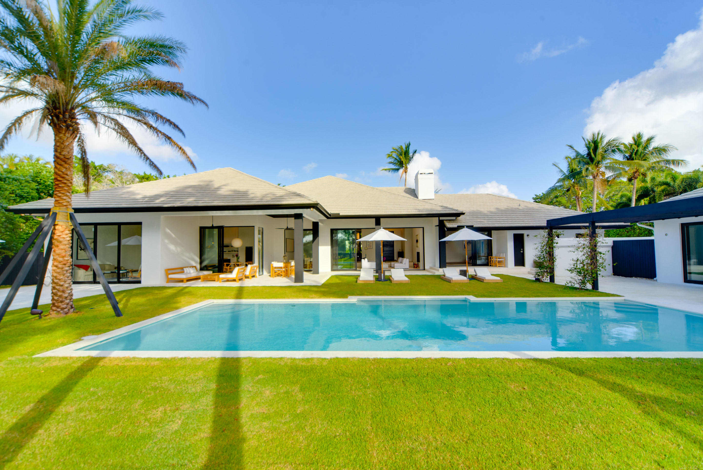 A true must-see, one of the most original and expertly renovated homes in the prestigious Palm Beach Polo Club. Enter through the eleven foot black barn door, to experience true indoor-outdoor living in this stunning six bedroom, seven and a half bath home. The renovation left no detail spared, including white oak flooring throughout, wood burning fire place in the living room, Thermador and Bosch appliances, and a full-sized Allavino wine refrigerator. The open layout is perfect for entertaining, with a separate dining room and several living areas, including oversized bonus room, living room, family room, and a separate cozy den. Off the main living area enter the backyard through the Windoor stacking glass wall doors, to enjoy the gorgeous vistas from the distinct separate outdoor spaces, and appreciate the mature plantings, outdoor shower, and heated pool. The two bedroom guest cottage is perfect for visiting family members, in-law suite, or trainer's quarters. The property comes fully furnished and decorated with a mixture of modern and vintage furniture.