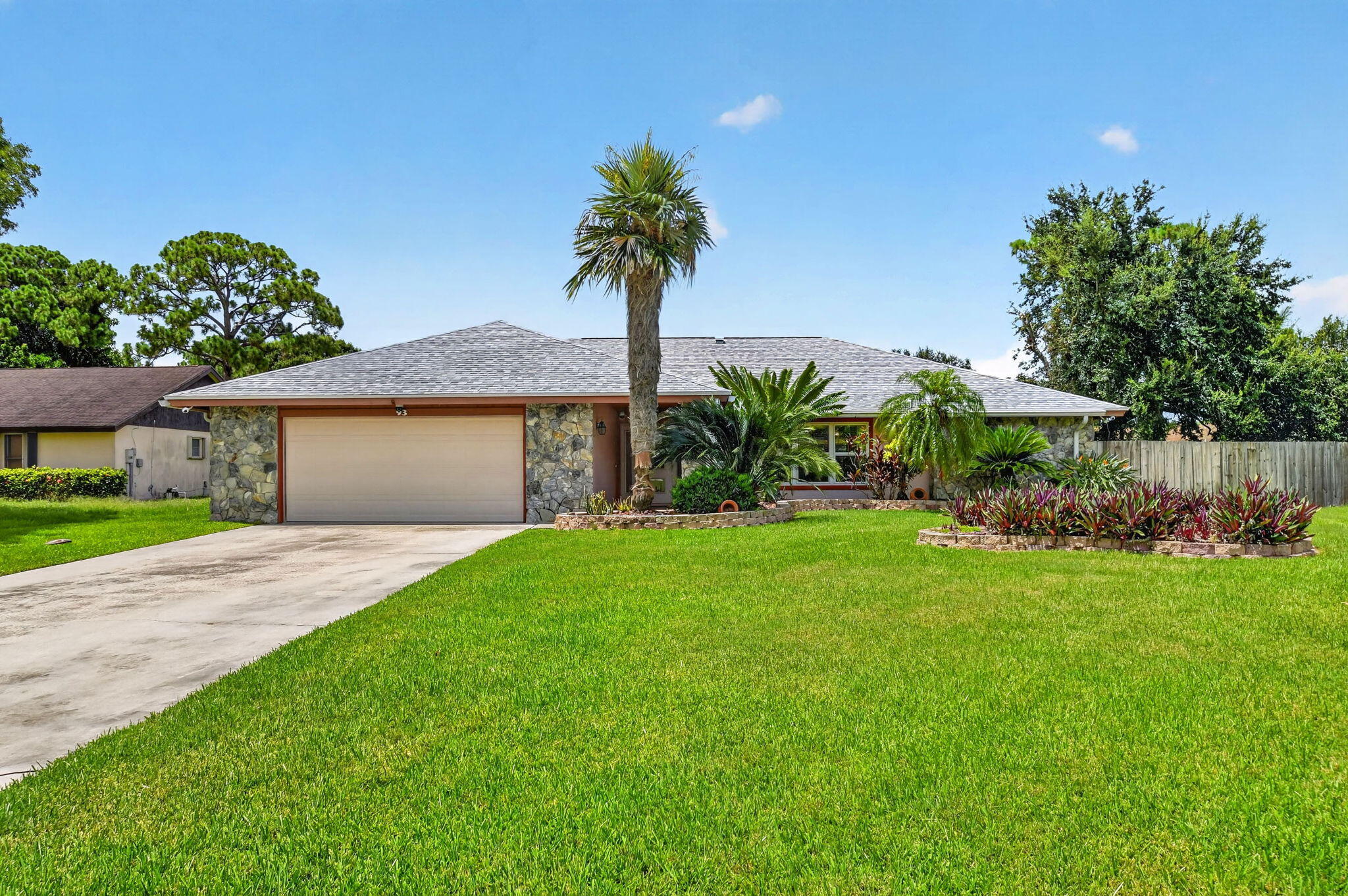 Over half an acre. No HOA. Resort-style backyard. This move-in ready 4-bedroom, 3-bath home offers over 2,400 living sq. ft. with a versatile floor plan featuring two oversized primary suites, ideal for multigenerational living or guests. The updated kitchen features custom solid maple cabinetry, granite countertops and newer stainless steel appliances. Enjoy a solar-heated pool, oversized screened patio, travertine decking, infrared sauna and custom sunken bar. Major updates include a 2025 roof, 2023 Rheem 5-ton HVAC, impact windows and doors, impact garage door, solar panels and more! Fenced backyard, oversized 2.5-car garage and extended driveway. Convenient to parks, golf, shopping, dining, hospitals and Florida's Turnpike.