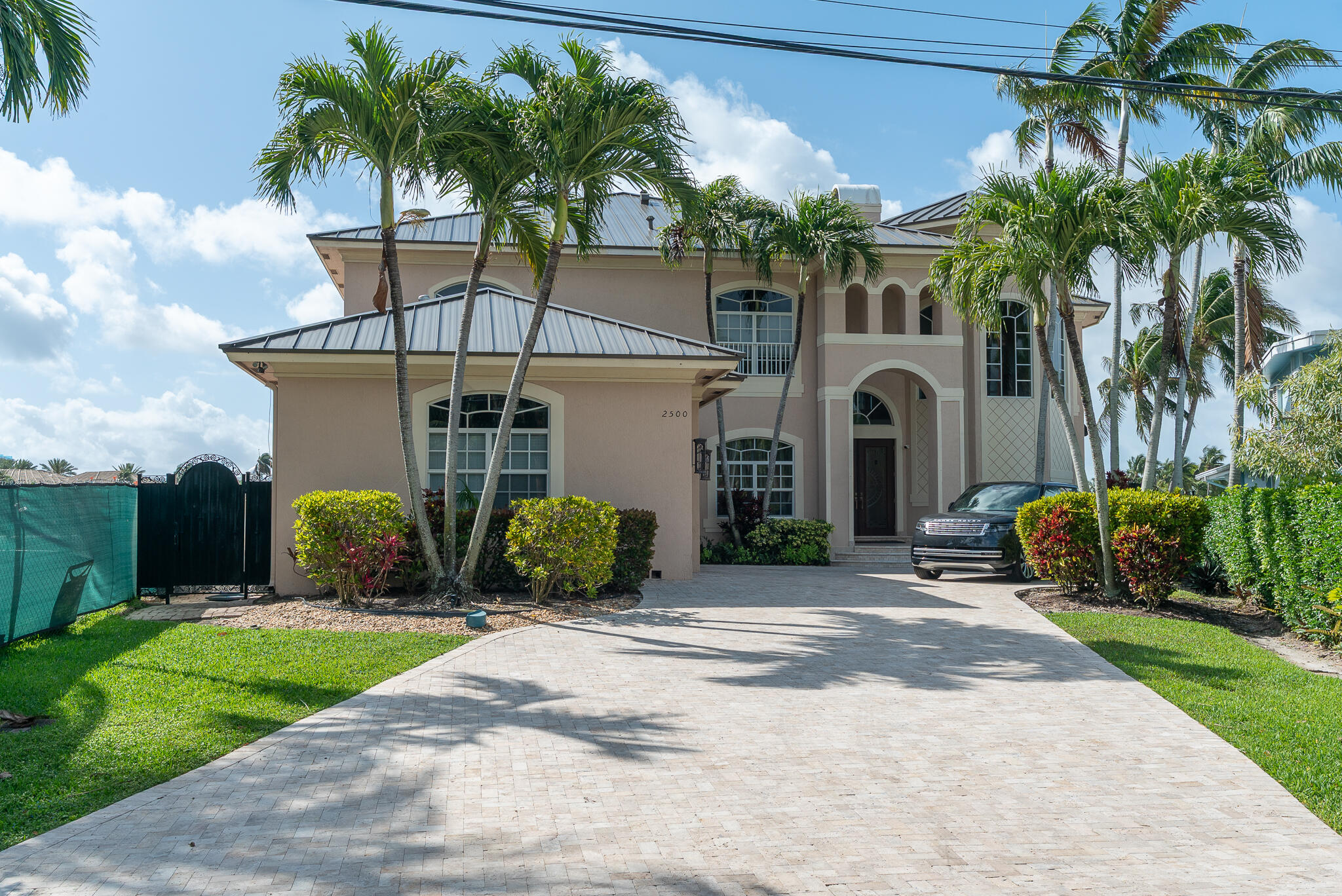 First time on the market in over 25 years, this stunning 4,703 sqft waterfront home sits on a 10,000 sqft lot and offers unobstructed 180 degrees of sightline views of Lake Santa Barbara and the Intracoastal. The home features 5 bedrooms and 5.5 bathrooms, with a layout designed for both everyday living and entertaining. Interior highlights include a formal dining room, formal living room, breakfast nook, family room, and a custom kitchen equipped with Sub-Zero appliances. Additional features include a wet bar, a three-car garage, and a handcrafted wood and iron staircase. The primary suite offers two custom walk-in closets and a spacious 300 sqft spa-style ensuite. Outside, the property includes 110+ feet of waterfront with a 15,000-pound boat lift and unimpeded deep-water ocean access. The south-facing backyard is positioned to take full advantage of both sunrise and sunset, whether from the 100+ ft composite dock, the covered patio with luxury travertine pavers, or the private second-story balcony off the primary suite. Located in Pompano Beach—ranked among TripAdvisor's top 10% of global destinations—the home is close to a revitalized beachfront, the award-winning Fisher Family Pier, and a range of dining, entertainment, and world-renowned diving and snorkeling spots.