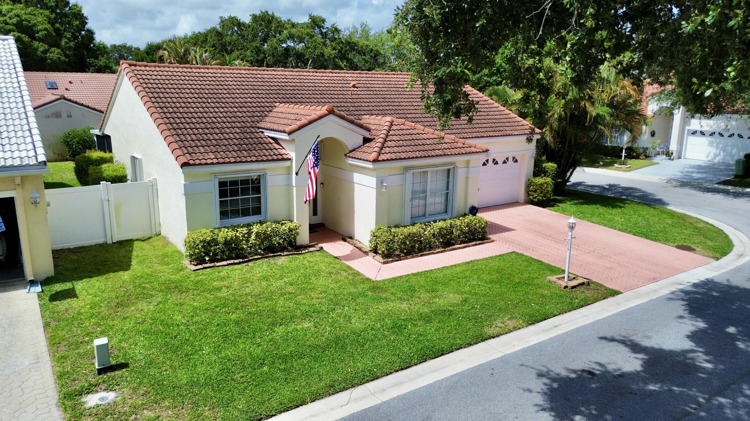 Beautiful 3 Bedroom, 2 Bath, 2-Car Garage Single Family Home with an extra room that makes this a 4 bedroom home!, offering an open floor plan with an updated eat-in kitchen showcasing quartz countertops with waterfall edges and backsplash, stainless steel appliances, and 24" tile flooring throughout the home. Additional upgrades include an impact front door, hurricane-rated garage door with mobile phone control, accordion shutters, duct insulation, and a A/C unit, all completed in 2022. Enjoy the spacious primary suite featuring a custom modular walk-in closet system, dual sink vanity, Roman soaking tub, and vaulted ceilings. The home also offers generous guest bedrooms and an expansive covered and screened-in patio with a Jacuzzi included in the lanai. Situated on a desirable corner lot with fenced grounds and a 2017 tile roof, this property is located in a pet-friendly community offering resort-style amenities including a community pool, tennis courts, and onsite management. The association includes basic cable TV, internet, landscaping, maintenance of common grounds. Conveniently located near premier shopping, dining, entertainment, travel, schools, 15 minutes to the beach, 20 minutes to Palm Beach International Airport and much more!
