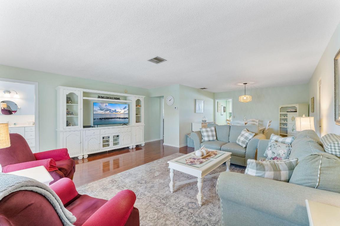 ALL AGE COMMUNITY, JUST MINUTES FROM THE BEACH, FULLY FURNISHED second-floor condo in the desirable Squire Hill community. This move-in-ready home boasts high-end stainless steel appliances, a new microwave, a recently installed A/C unit (January 2026), impact-resistant windows, a newer roof, and fresh exterior paint.  The bright interior features wood-look flooring, a coastal-inspired kitchen, and a private balcony with views of tropical grounds. Residents benefit from an all-inclusive association that covers water, building insurance, and amenities such as a pool, clubhouse, and updated laundry facilities ( no pending assessments). Conveniently located near I-95, beaches, top hospitals, and premier shopping, this turn-key residence is the ultimate Florida retreat.