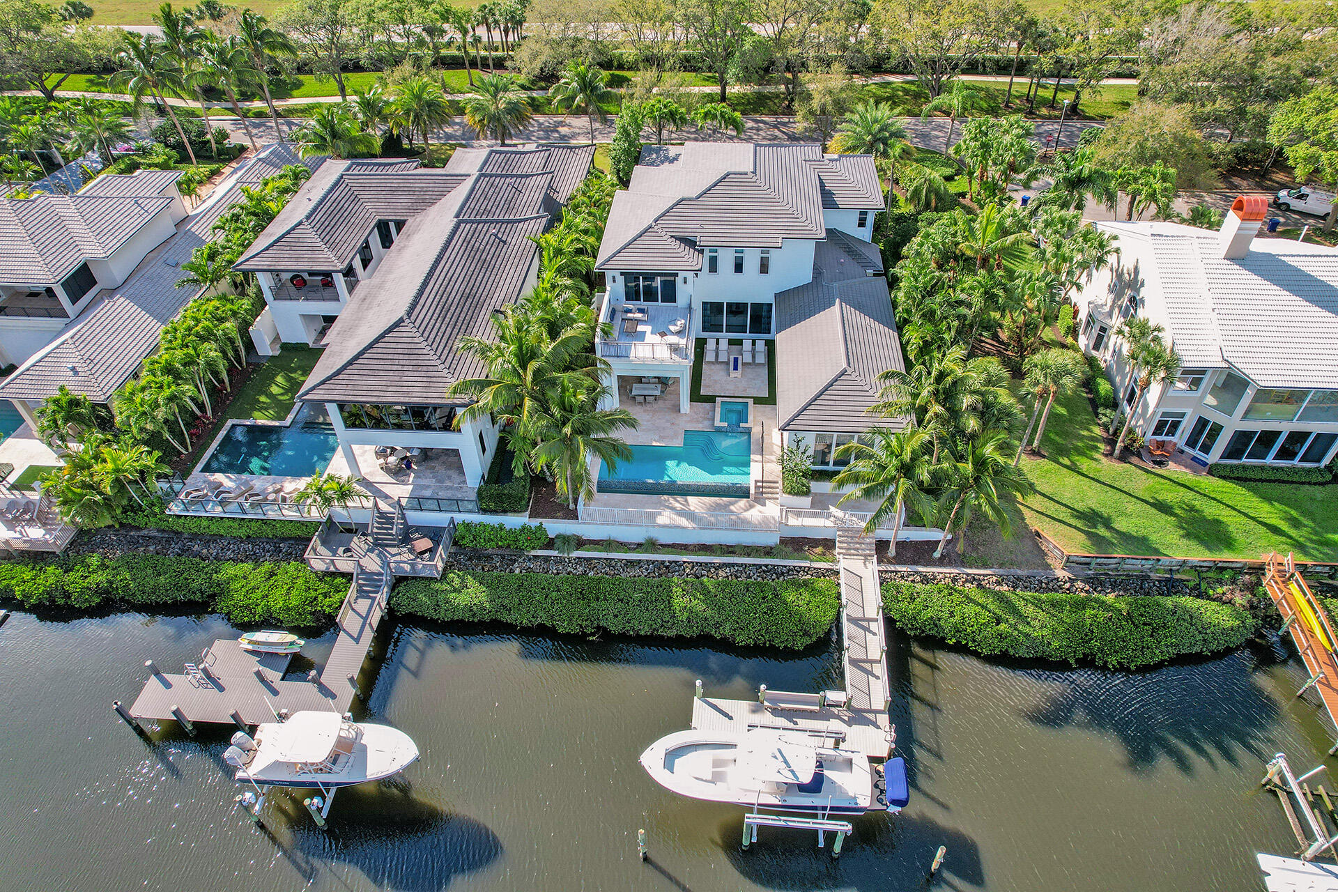 Water, water, water...Stunning vistas from this 2016 pristine estate. This is not a typical Admirals canal view! Professionally decorated and offered FULLY furnished this 2-story (with custom elevator) ,open floorplan British West Indies-styled home was designed by Mitch Kunik of Afiniti Architects. 5-bedrooms plus a full office/study(Main level master bedroom & guest bedroom).Spectacular views from the backyard are complimented by custom landscaping surrounding the 35' infinity edge pool and 8 person spa. You will feel like you are in your own oasis. Enjoy dinners under a covered Lanai utilizing the fully equipped outdoor summer kitchen & automated roll down screens or watch sunsets from the second floor Club Room and adjoining expanded terrace. The 35' dock will accommodate your 50' boat The grand foyer opens into the Great room with intimate dropped ceilings, custom lighting, large bay windows and an electric fireplace for ambiance on the "cooler" Florida nights The chef's delight kitchen features Wolf Appliances and Subzero Refrigerator, a full butler's pantry with 2 wine coolers that hold a total of 50 bottles, marble counter tops, under cabinet accent lighting in kitchen and butlers pantry all leading to a cozy breakfast area overlooking the 35 foot infinity salt water heated pool and spa with LED lighting, clean turf, summer kitchen with Sedona stainless steel BBQ and custom cabinetry and an automated roll down screeed covered lanai. There is even an outdoor gas fire pit!! The Lutron automated whole home lighting system only adds to the ease of living in this esate home. 20k pound boat lift with electric and water service.
There is a second floor features an open loft with a full wet bar and custom cabinetry that leads out to an expanded terrace should you choose to enjoy the long water sunset views. 3 guest bedrooms each have their own on-suite bathroom and walk-in closets with fully custom California cabinetry built-ins.. Each level of the home features its own dedicated laundry room.....
The entire home has full overlay solid wood cabinet doors in litchen, butlers pantry and all bathrooms. 3 car epoxy garage with Eden Coast Carriage garage doors and custom built-in cabinetry. Full home 50kw generator. Complete  impact hurricane glass windows. Foam spray insulation throughout. Sound insulation at baths, laundry and HVAC to reduce sound transmission. Hot water recirculating system. Full House camera Security system. 3 Trane high efficiency 16,000 Seer air conditioners. Honeywell H902 Central Vacuum system..400 Amp electric service with 2 panels. 7 ½'' Baseboard and 7 ½'' Crown Moldings throughout. Roof gutter system.